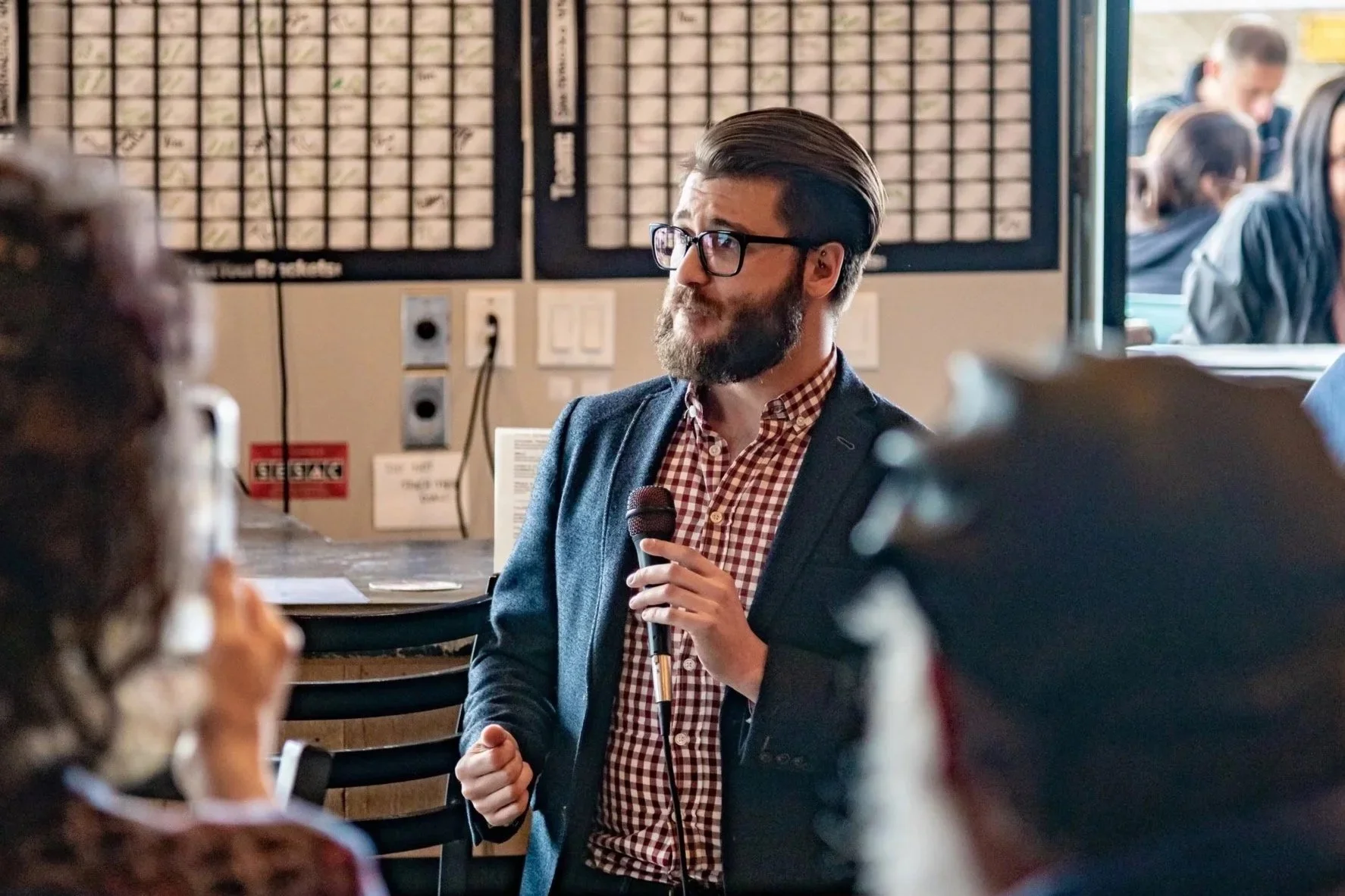 Amitai holding a microphone and addressing a group of people