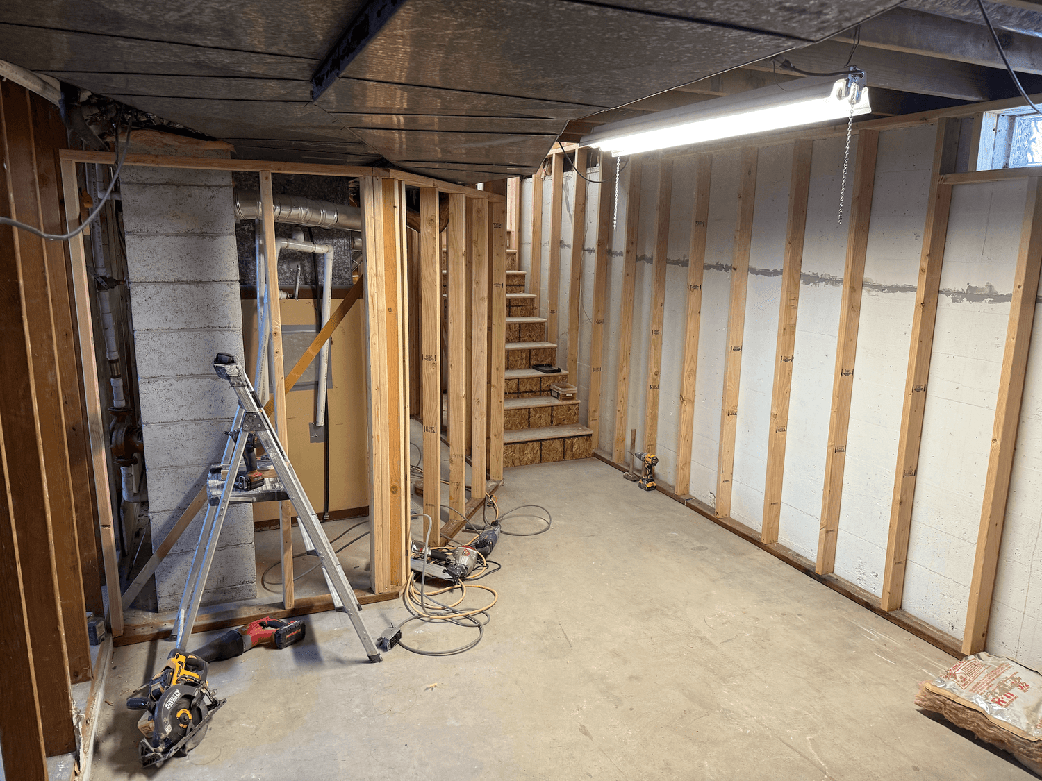 Basement framing and insulation with a new egress window during a Logan, Utah basement remodel by ONYX Bros