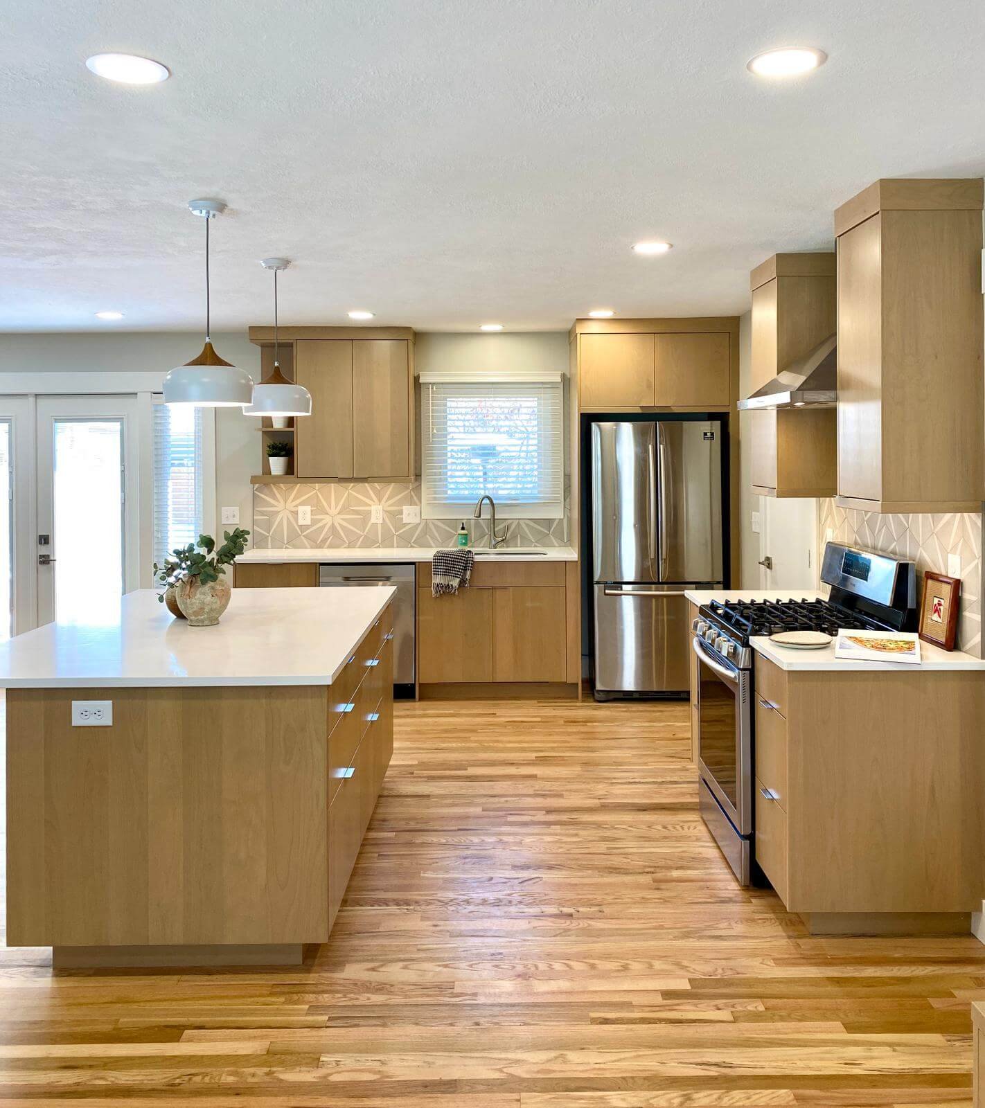 Contemporary kitchen remodel near Logan, Utah by ONYX Bros with light cabinets and a tiled backsplash