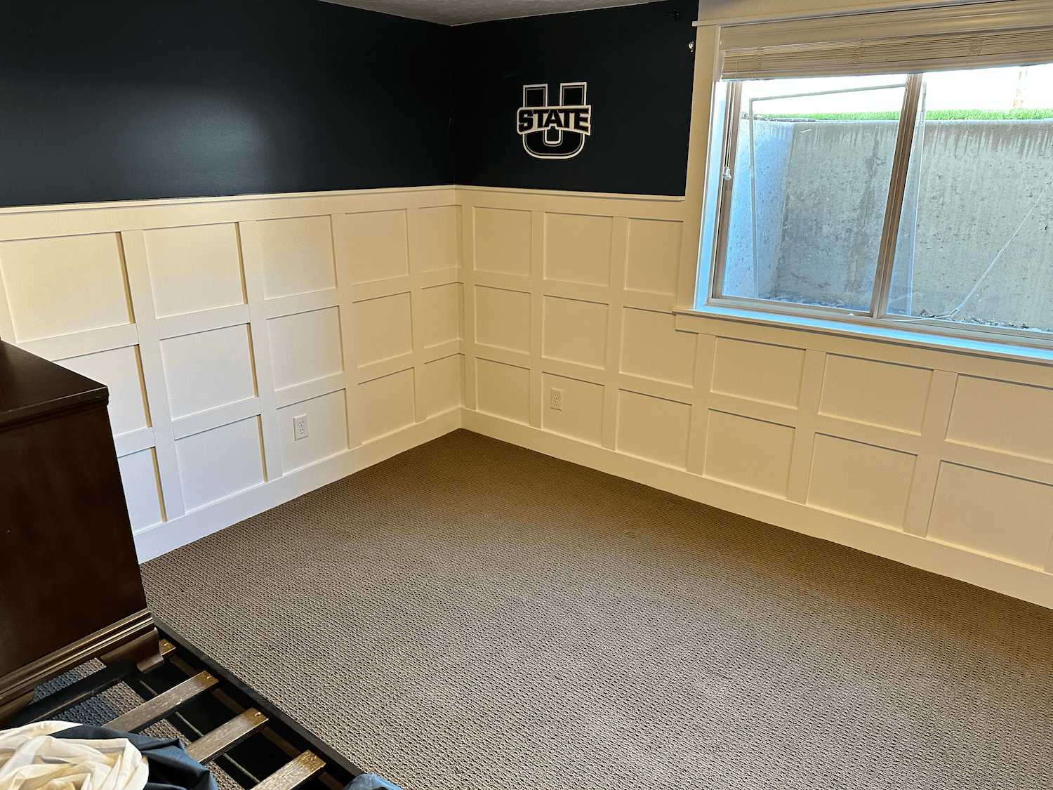 A modern basement with hardwood flooring, multiple white doors, a washer and dryer, and a small bathroom with a vanity and round mirror.