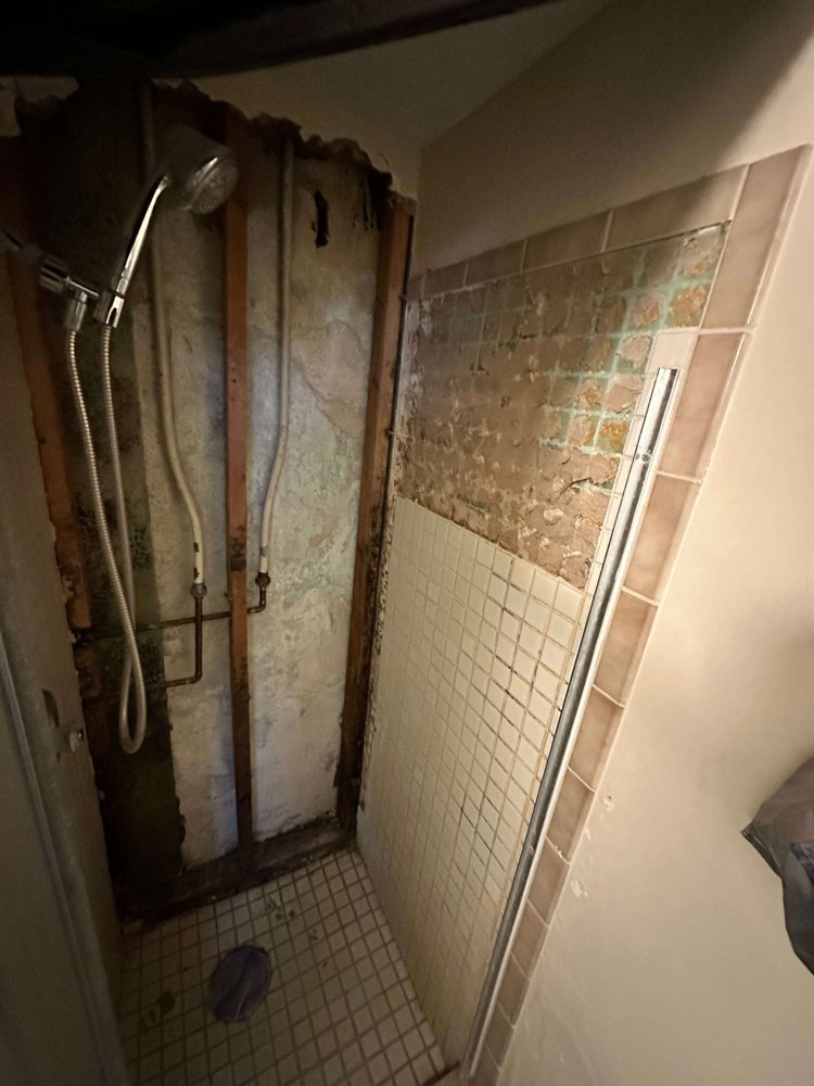 Shower torn out to the original brick wall during a Logan bathroom remodel