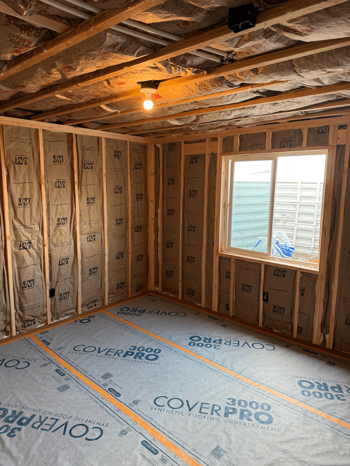 Finished basement remodel in Logan, Utah by ONYX Bros, with white board-and-batten wainscoting, navy walls, and a new egress window