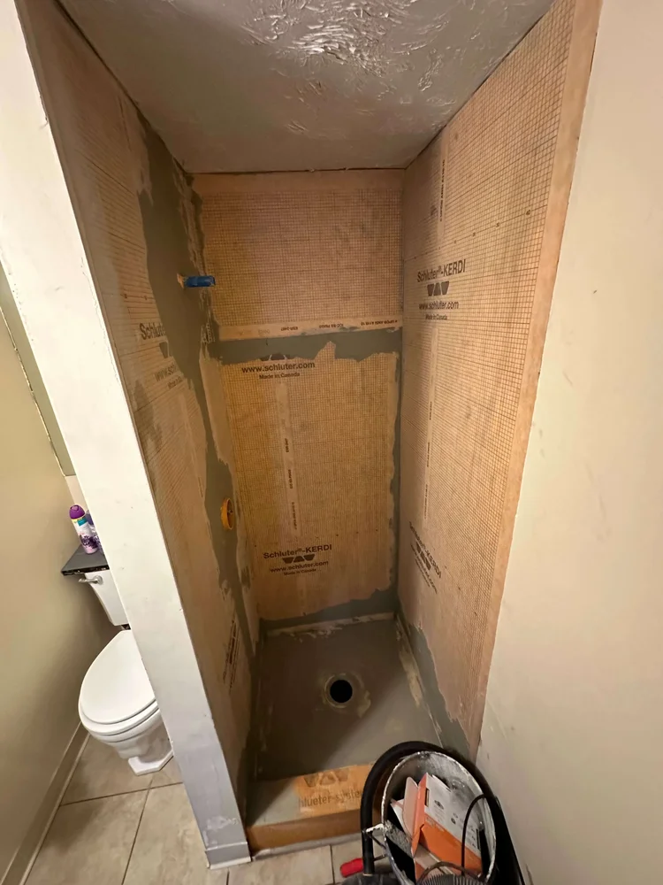 Waterproofing membrane installed on shower walls and pan before tile in a Logan bathroom