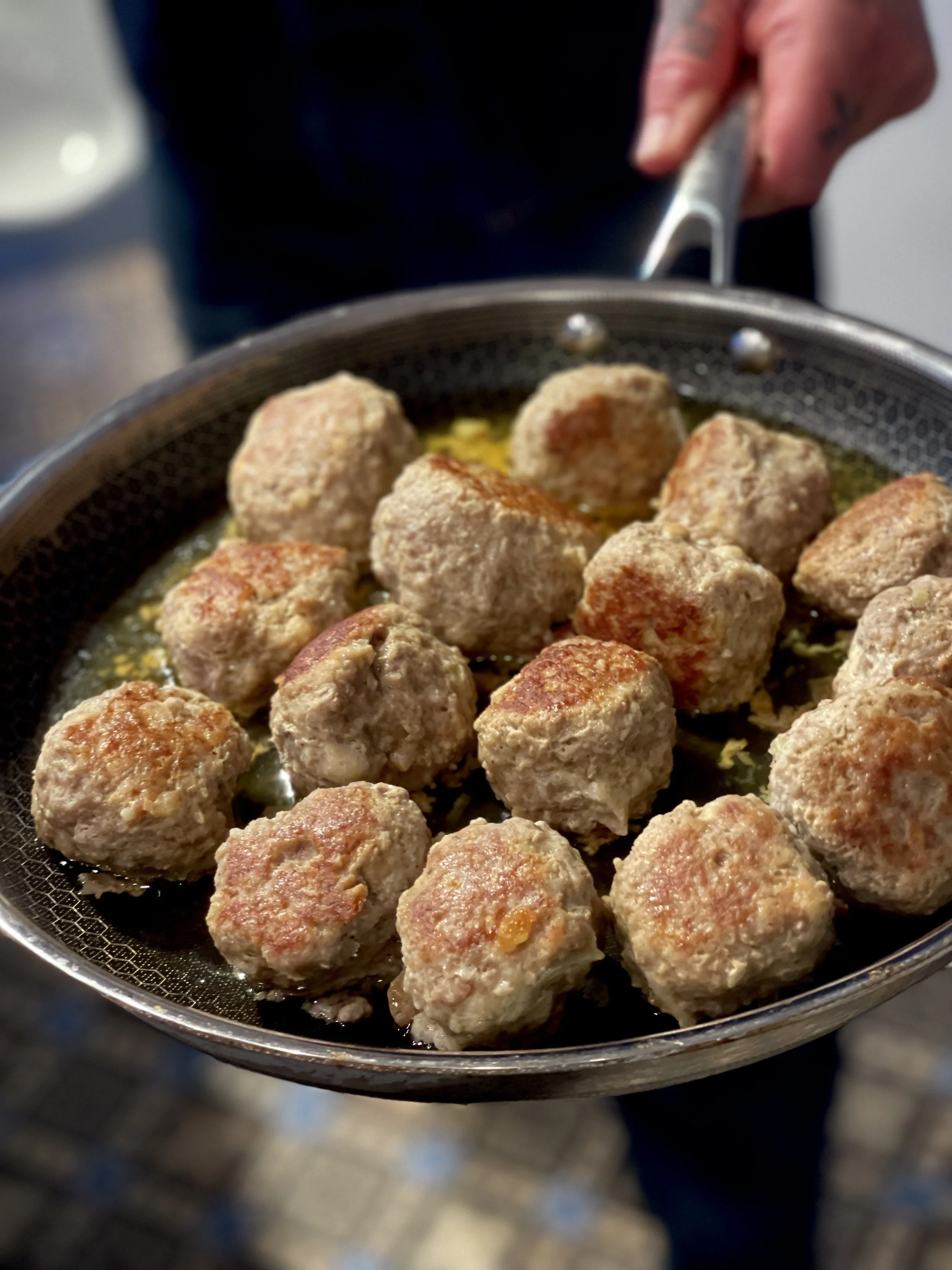 Gevulde gehaktballetjes die worden gebraden in een pan met olie