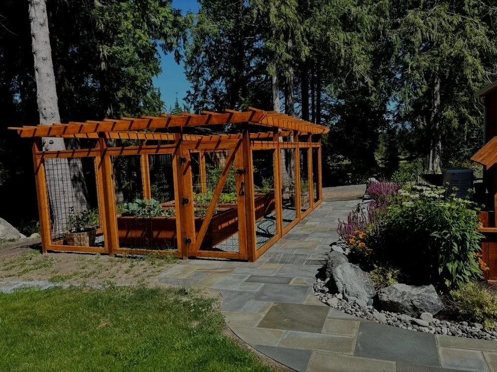 Fenced-in garden area design, pavers and plants as part of Snohomish landscaping.