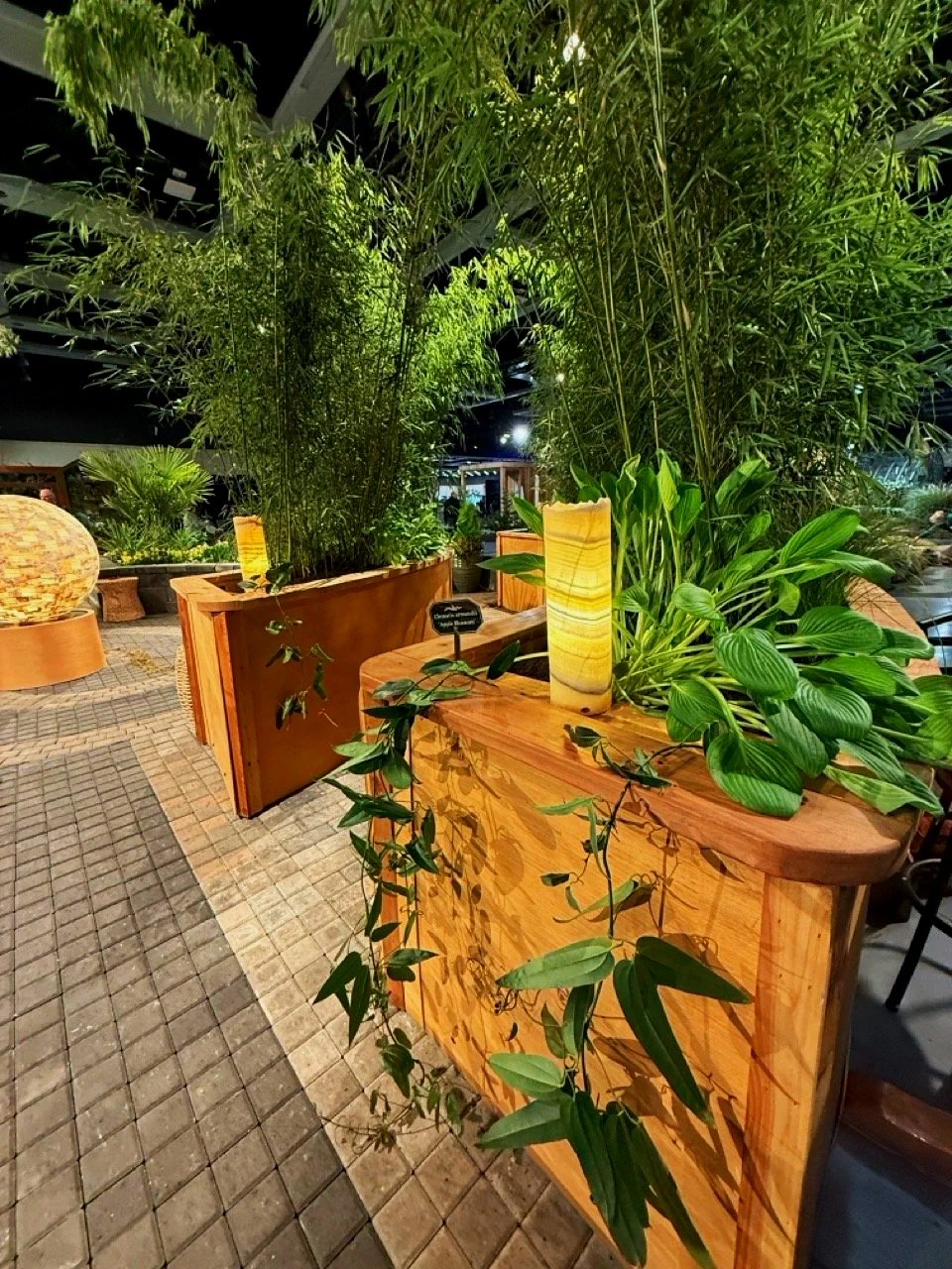 Planter boxes with green plants and abstract light fixtures part of landscape design.