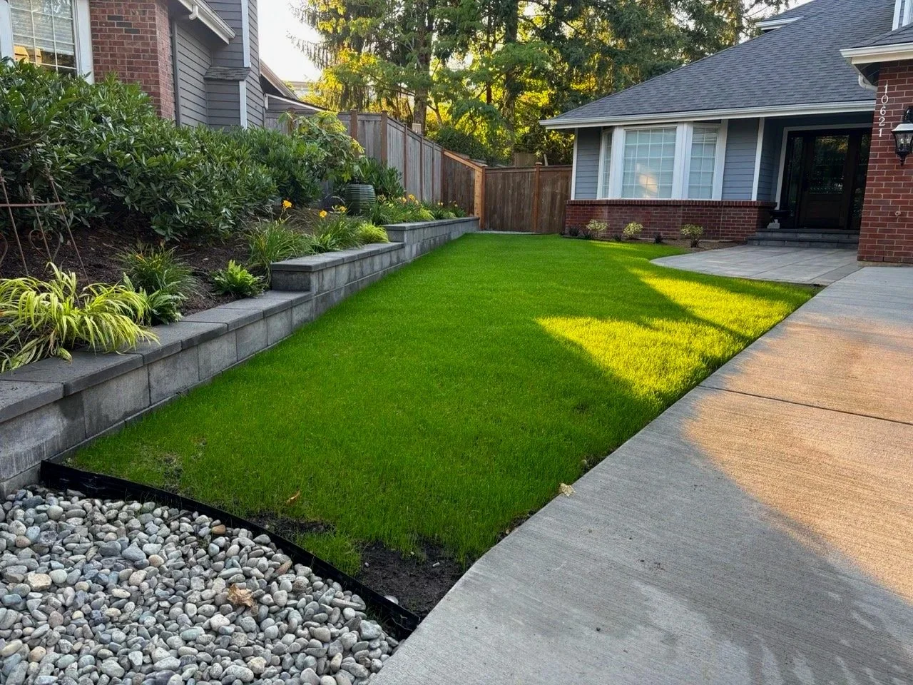 Driveway landscape design with lawn and terraced retaining wall planter for landscaper construction.