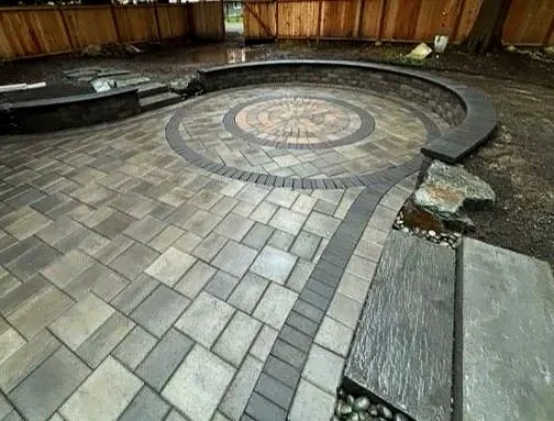 Rounded paver patio with retaining walls and stone steps.