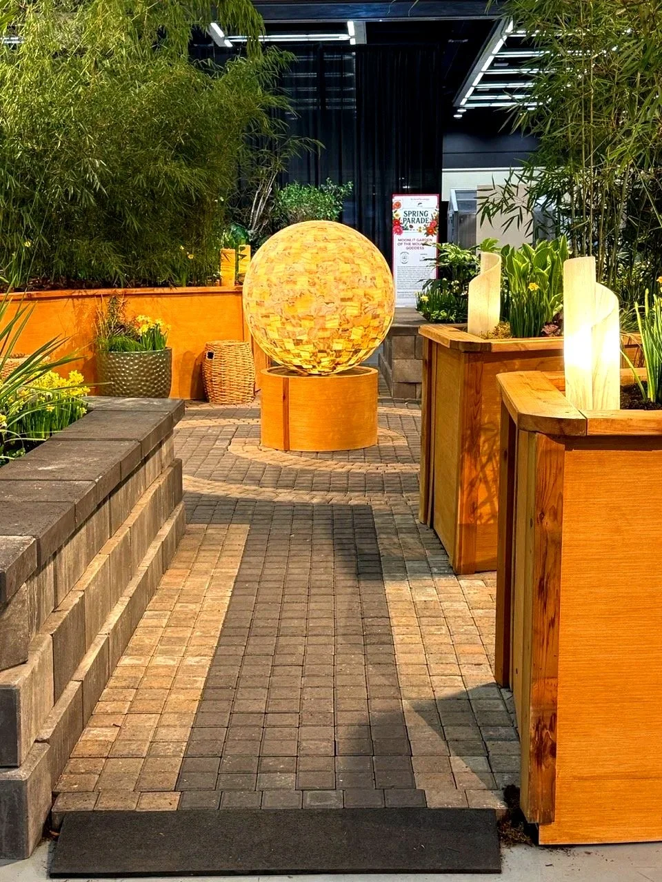 Big light installation on a paver patio with plants as part of Washington landscape design.