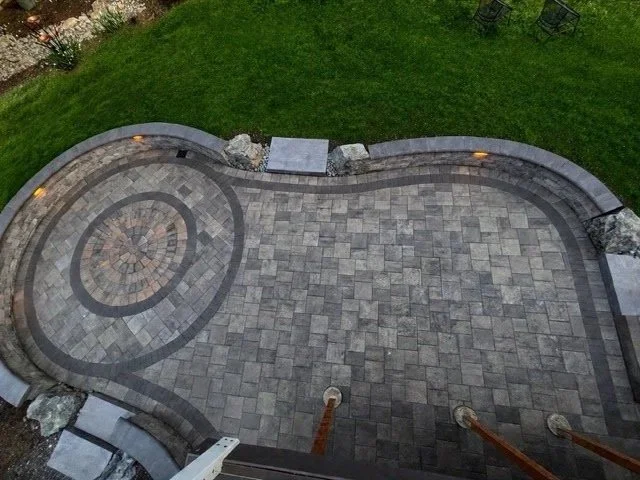 Arial image of custom built paver patio design, with lights and retaining walls.