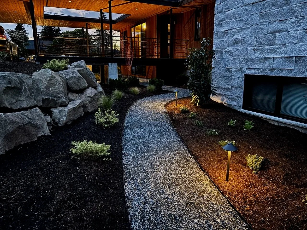 Gravel pathway, with mulch, and big boulders, with landscaping lights in Snohomish Washington.