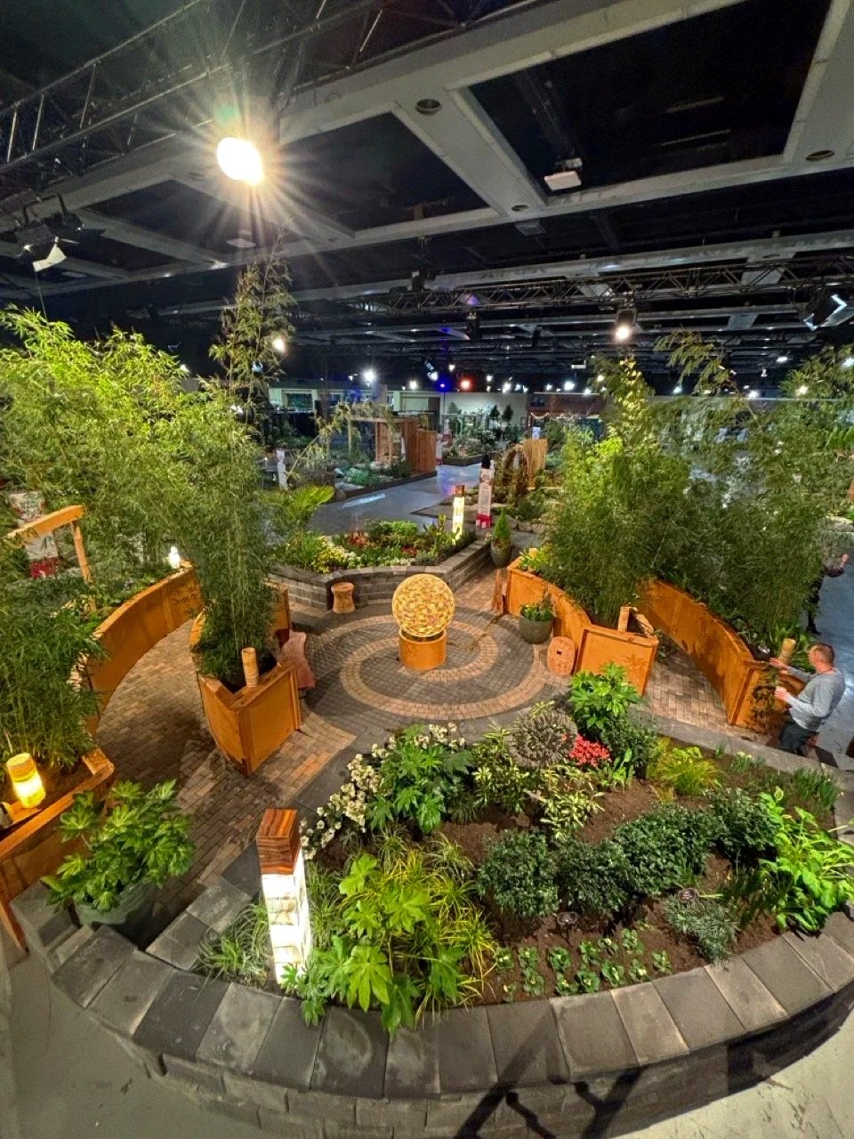 Aerial photo of spiral landscape design with a ball light feature, plants and trees.