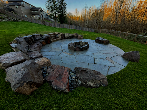 Round custom stone patio and firepit as part of landscape design in Snohomish.