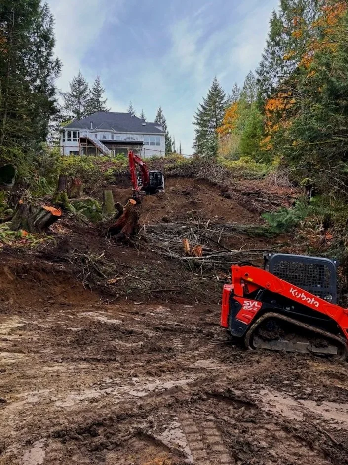 Two small excavators working on hillside property as part of Snohomish landscaper project.