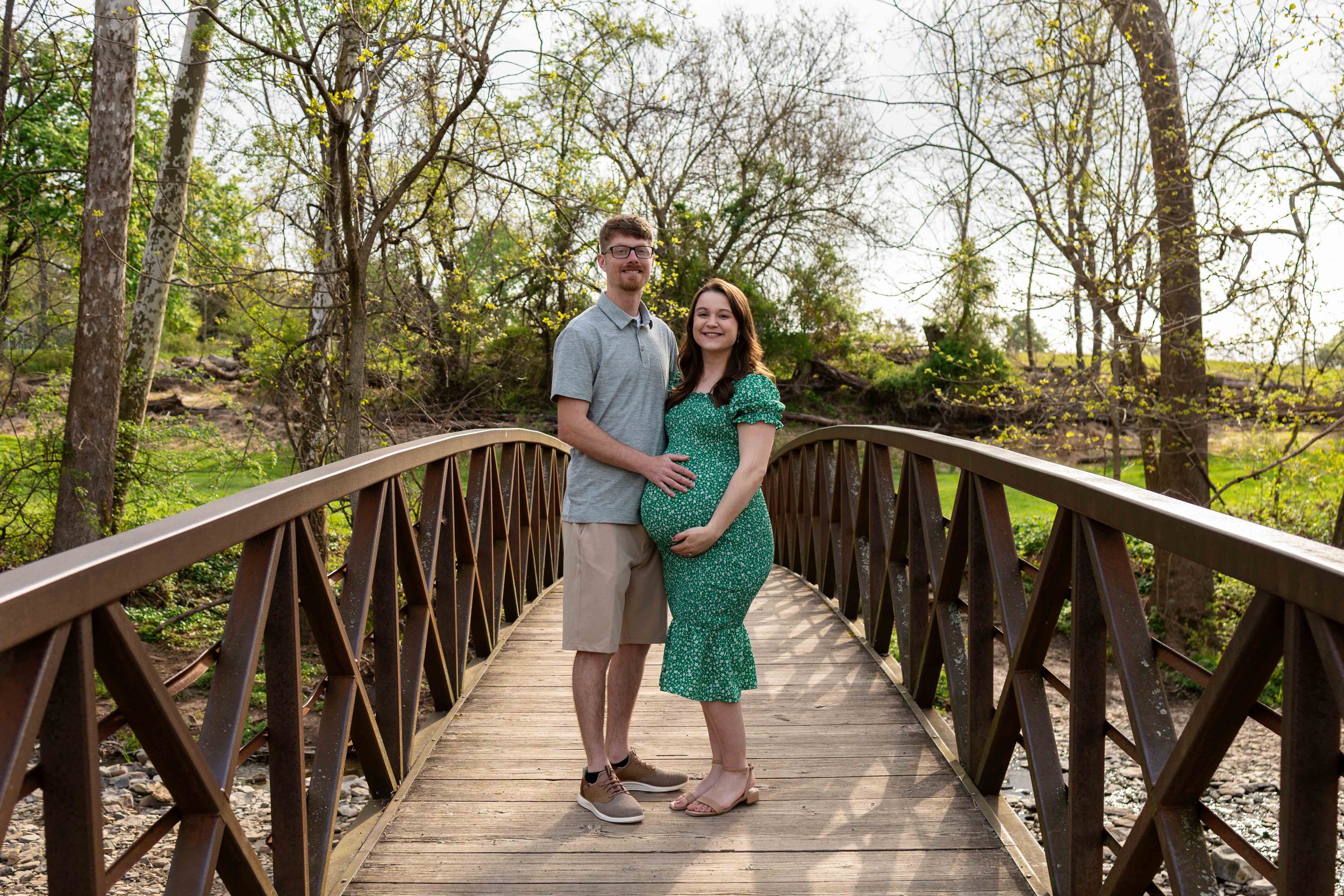 An expecting couple stands on a bridge - maternity photo taken by Jennifer Fulton Photography in Flemington, NJ