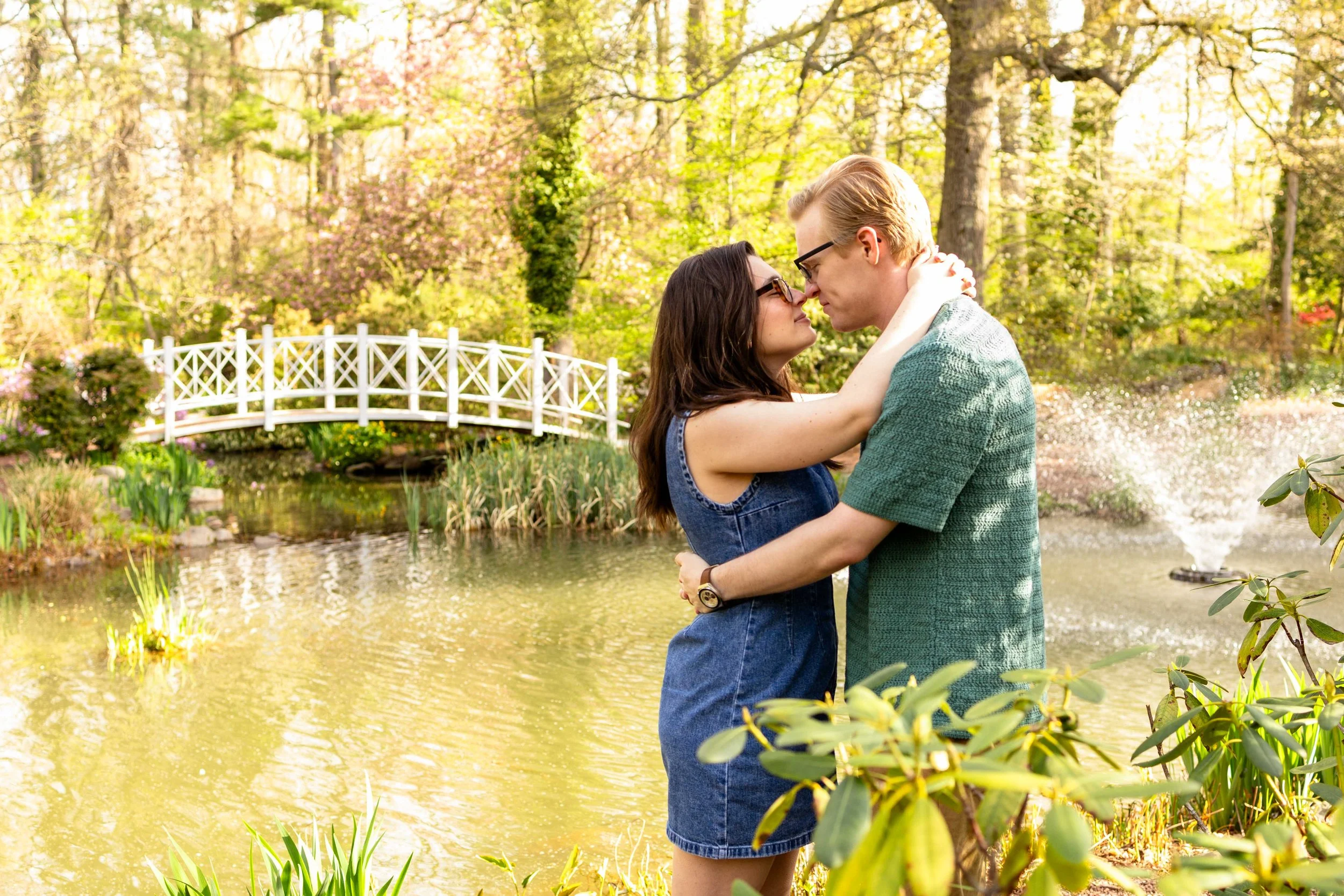A couple embraces while standing next to a pond - couple's engagement photo taken by Jennifer Fulton Photography in Princeton, NJ