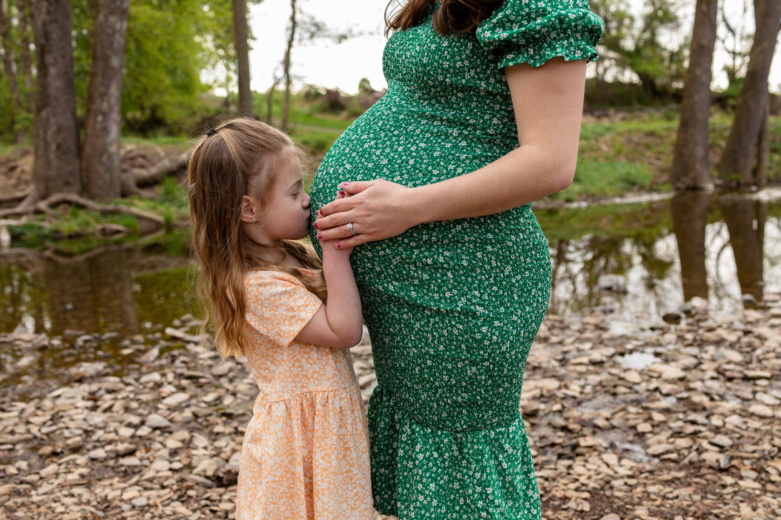 A young daughter kisses her mom's pregnant belly - maternity portrait taken by Jennifer Fulton Photography in Lambertville, NJ
