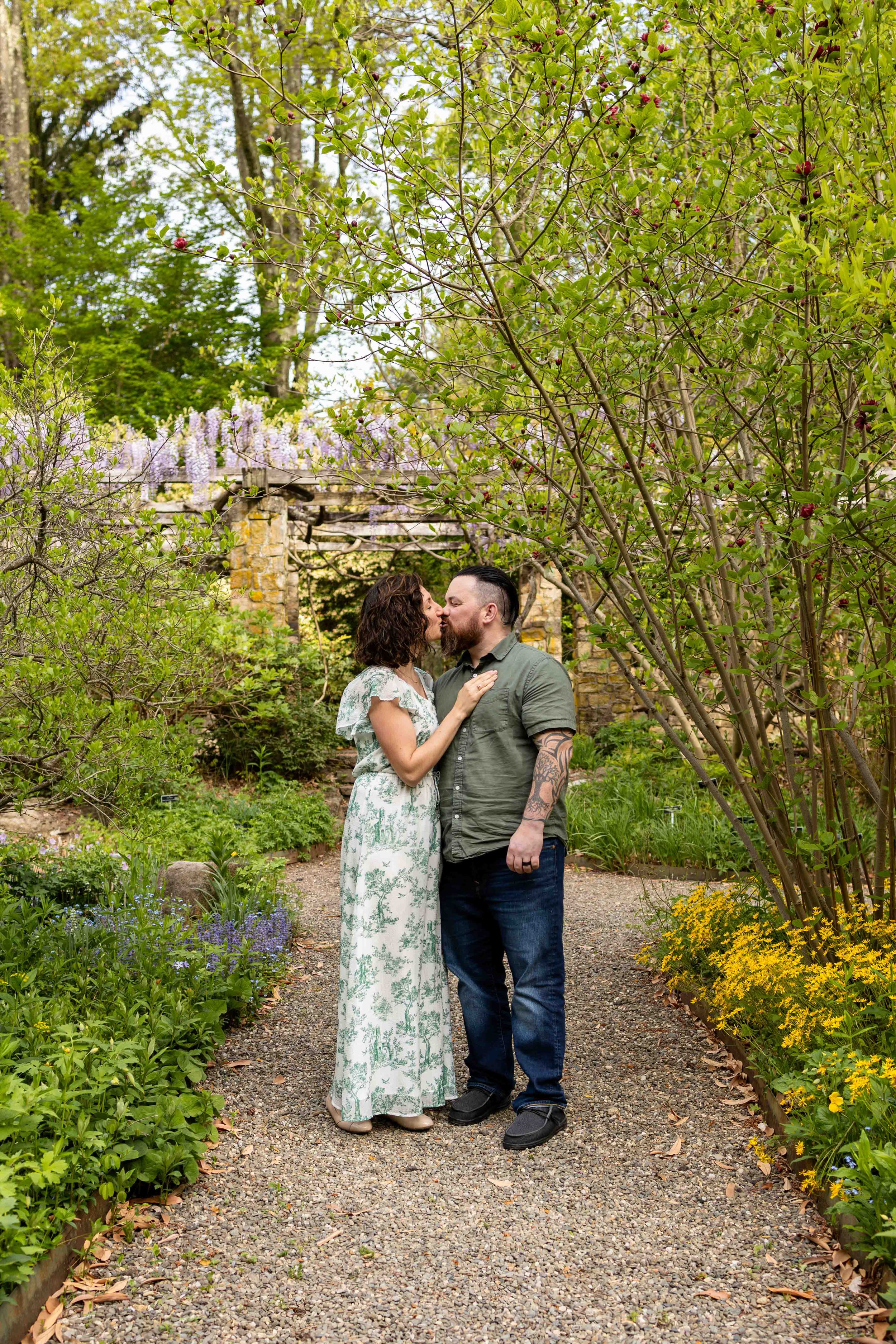Parents kiss while standing in a garden - family portrait taken by Jennifer Fulton Photography in Somerville, NJ