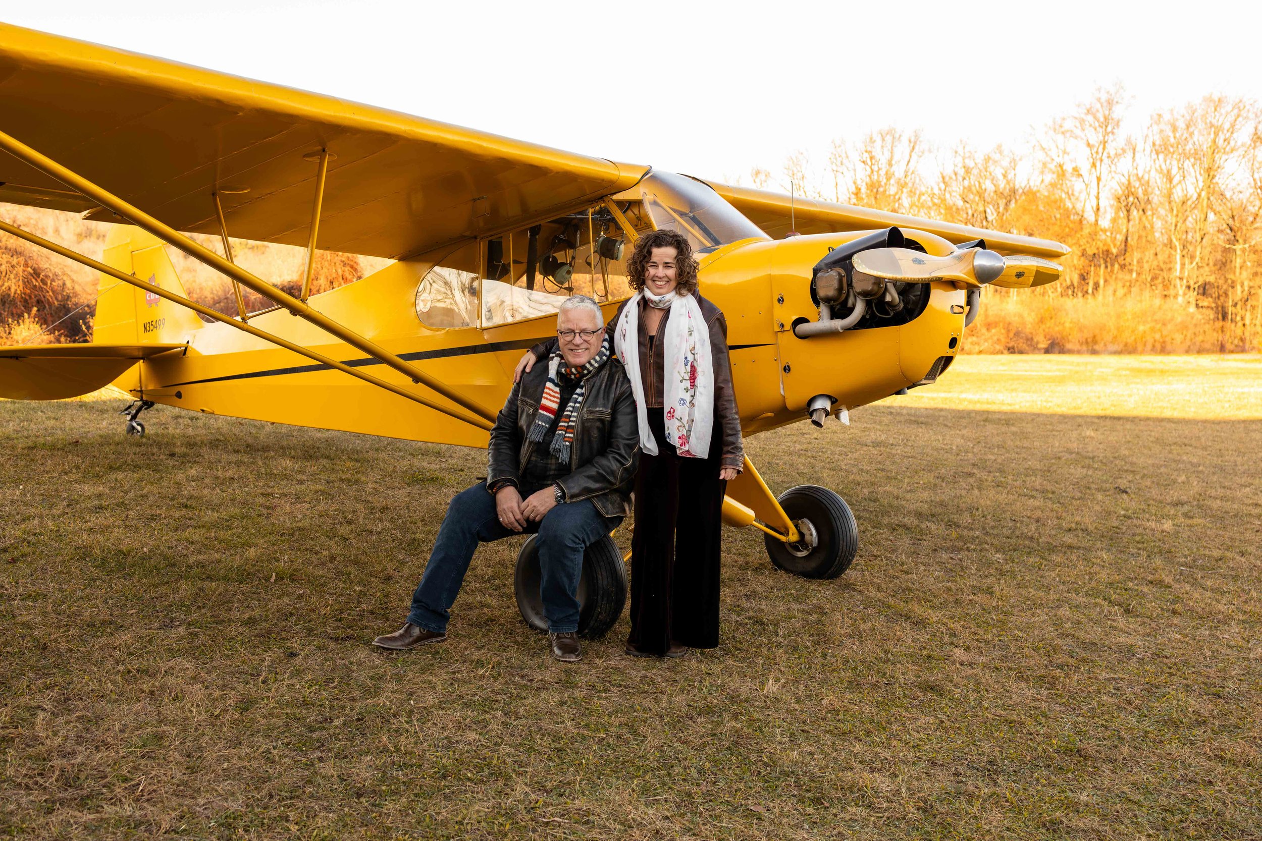 A couple stands in front of their antique yellow plane - taken in Bucks County, PA by Jennifer Fulton Photography