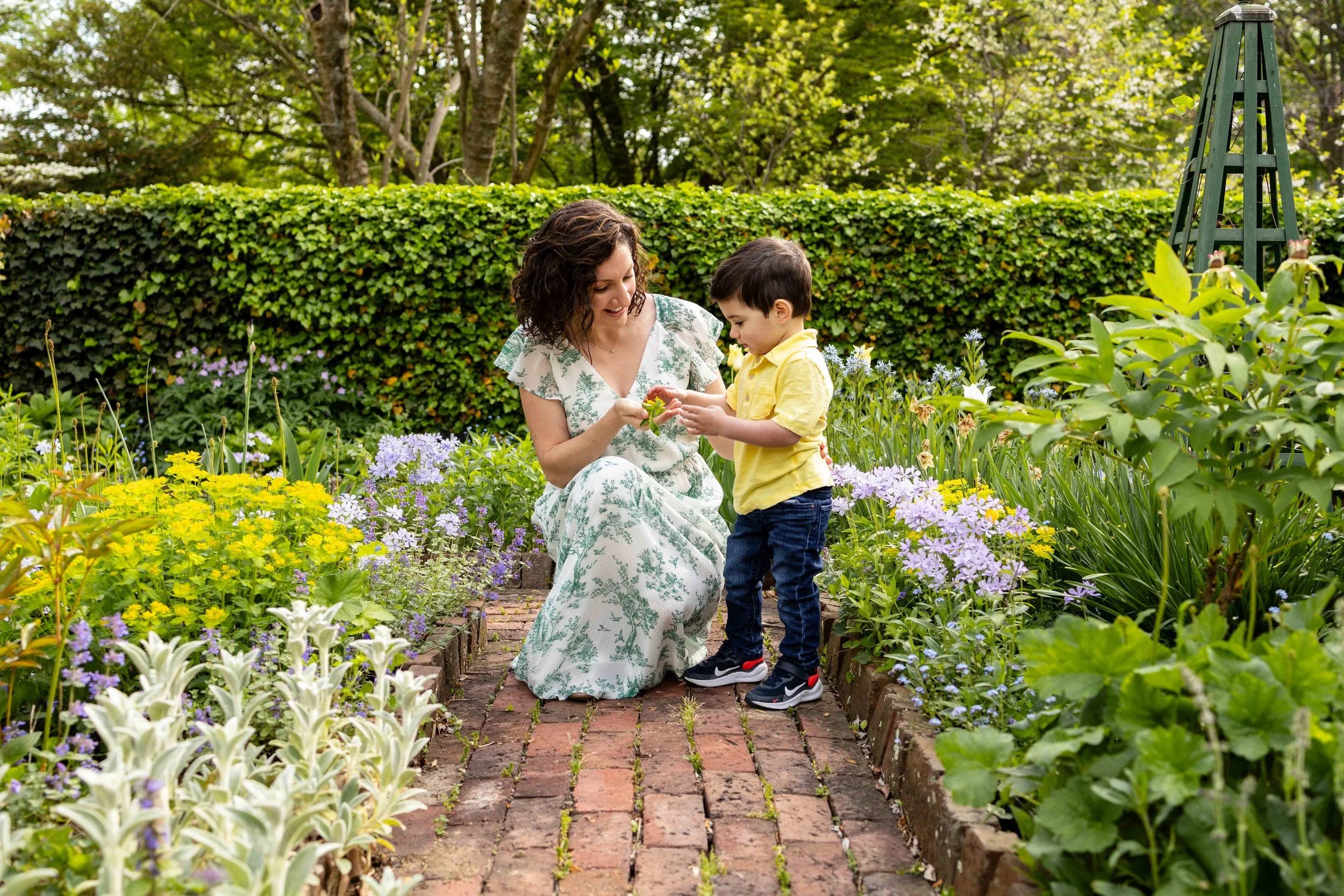 Mom and son look at a flower in a garden - family portrait taken by Jennifer Fulton Photography in North Jersey