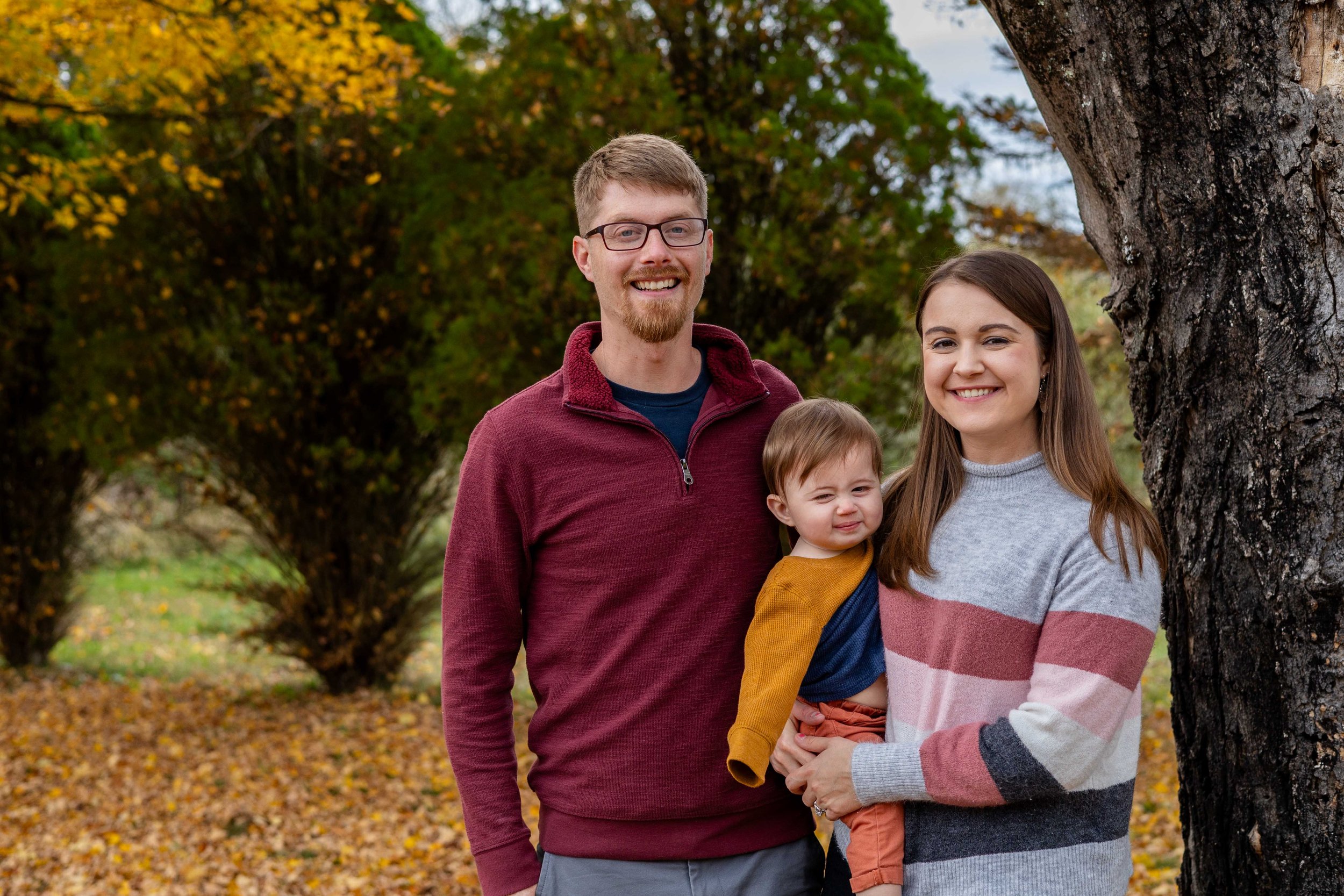A young family stands in front of a tree - taken in Frenchtown, New Jersey by Jennifer Fulton Photography