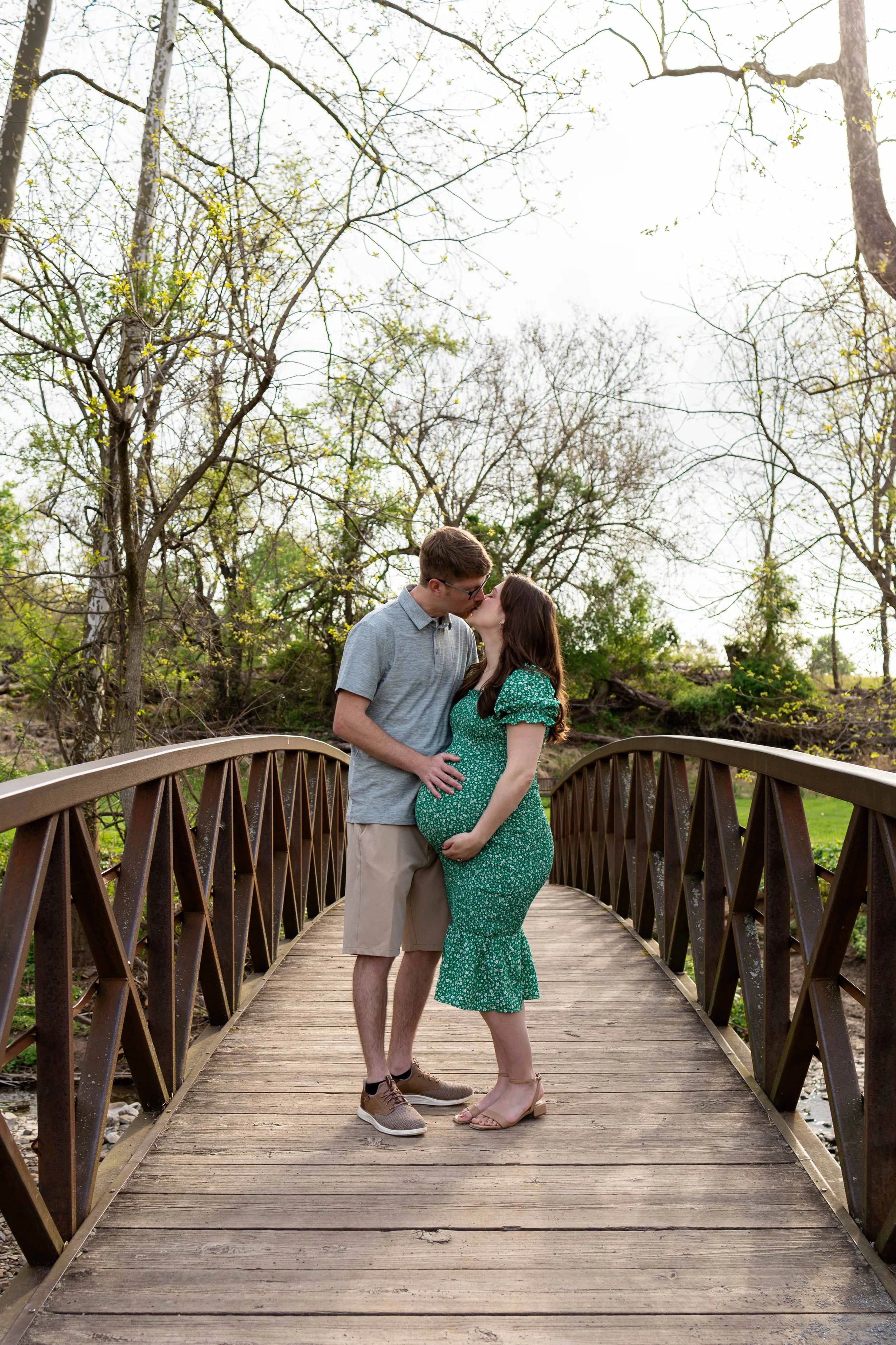 An expecting couple embraces while standing on a bridge - maternity portrait taken by Jennifer Fulton Photography in Stockton, NJ