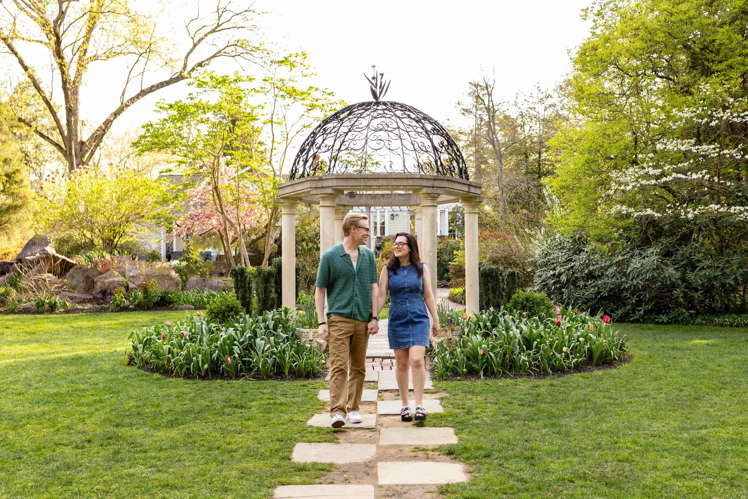 A young couple walks in a garden - couple's engagement portrait taken by Jennifer Fulton Photography in NJ