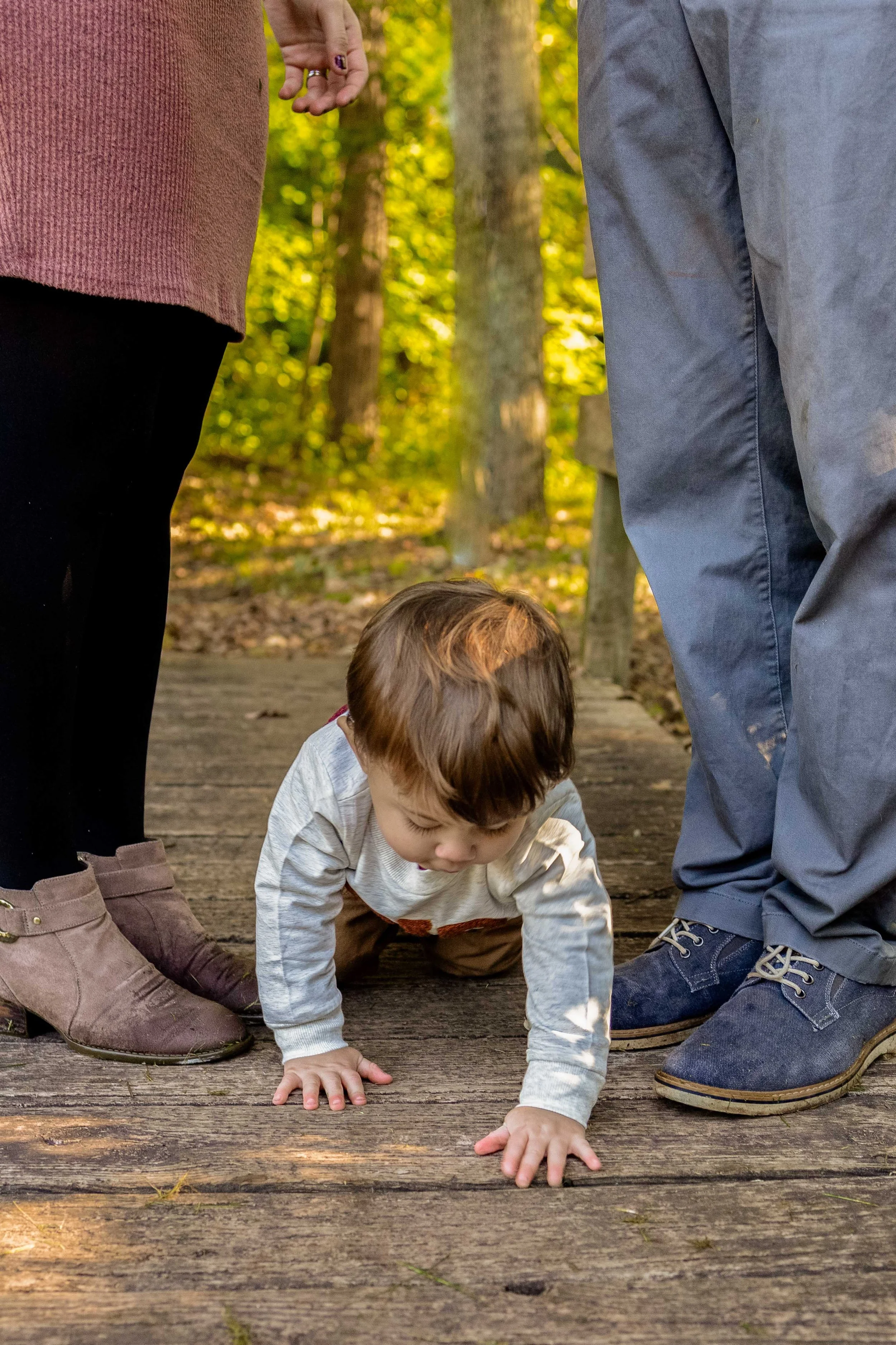 A young boy crawls betwen his parents' legs - taken in Hunterdon County, NJ by Jennifer Fulton Photography