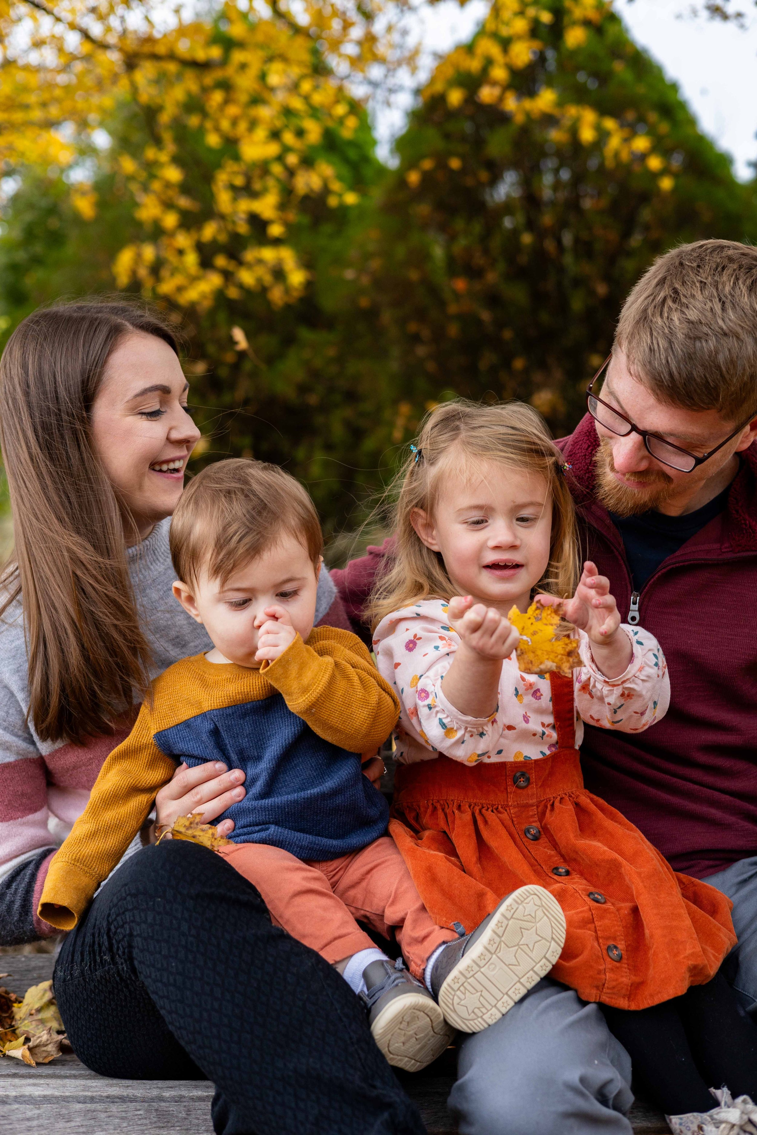 A young family sits on a bench in autumn - taken in Hunterdon County, New Jersey by Jennifer Fulton Photography