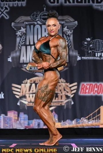 A female bodybuilder posing on stage at a bodybuilding competition.