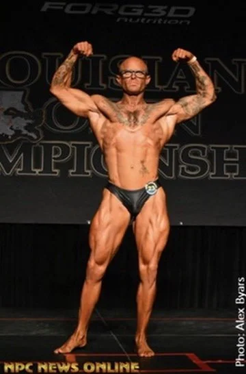 Bodybuilder on stage flexing at a bodybuilding competition.