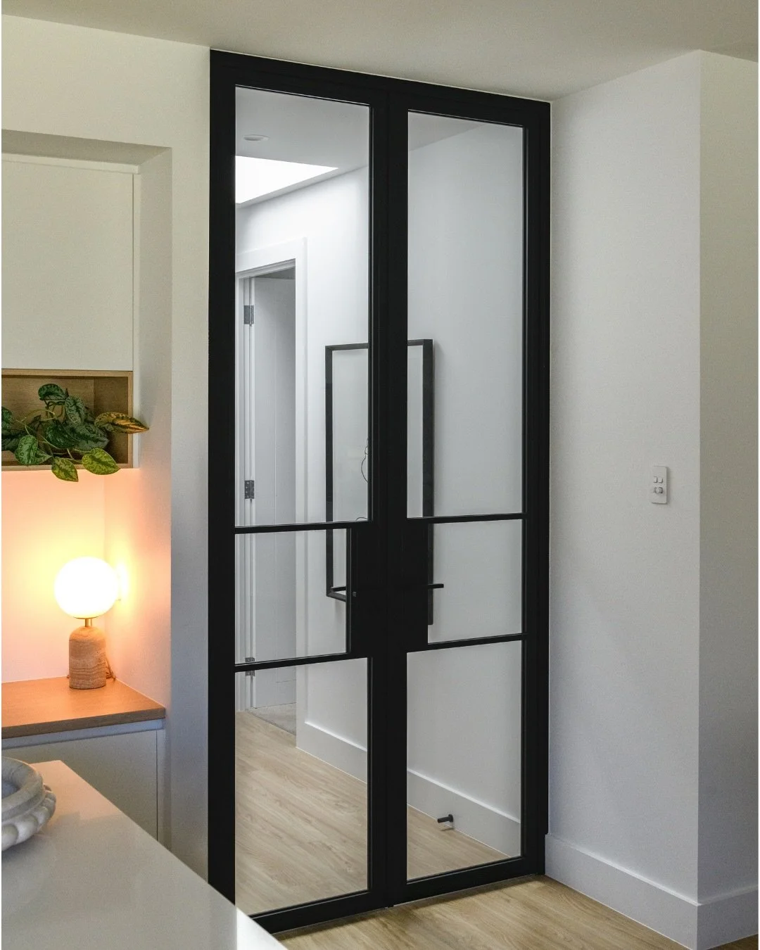 Bold black double glass doors make a stunning hallway statement! 🙌🏽

Bringing an edge to the home while keeping it light and airy, with soft wood floors and a neutral palette for a truly calming vibe. 🌿