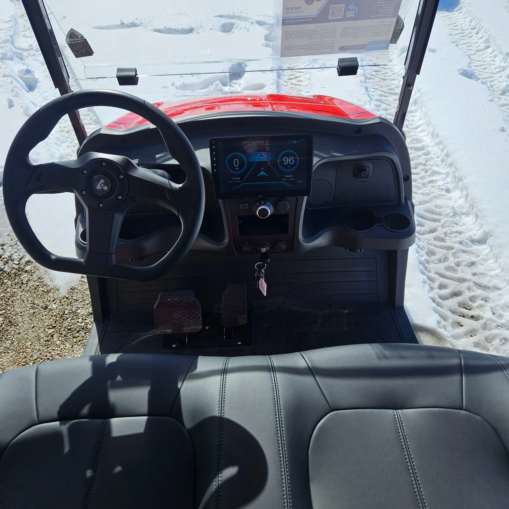 Gray Bintelli electric golf cart with black seats and a transparent windshield.