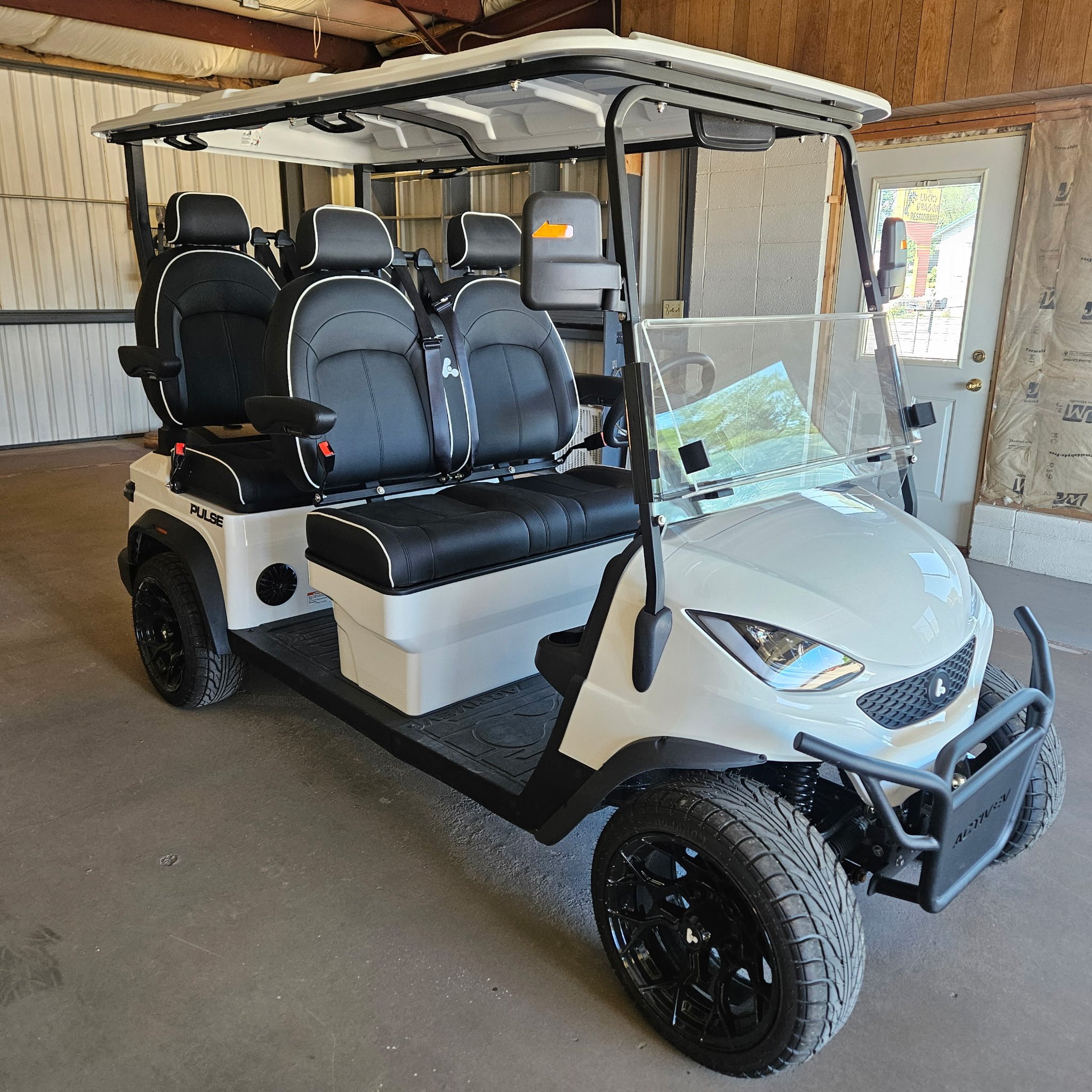 Gray Bintelli electric golf cart with black seats and a transparent windshield.
