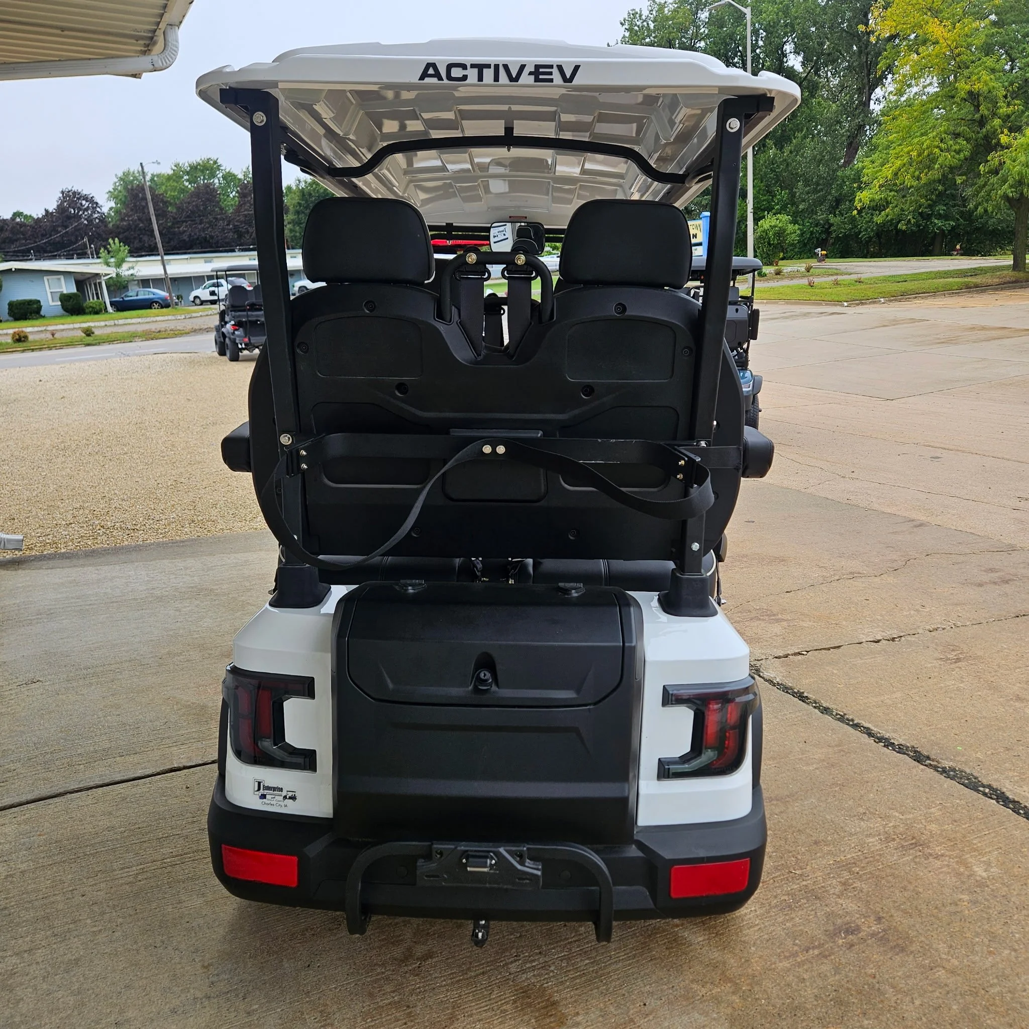 Gray Bintelli electric golf cart with black seats and a transparent windshield.