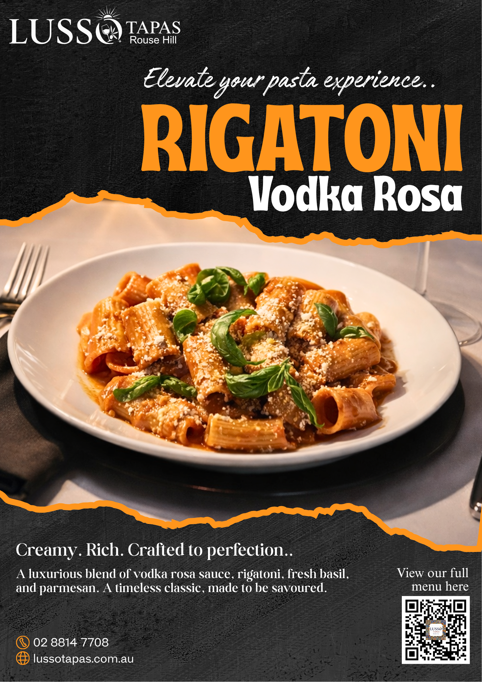 A Plate of rigatoni pasta with vodka rosa sauce, garnished with fresh basil and grated parmesan cheese, on a dark table setting.