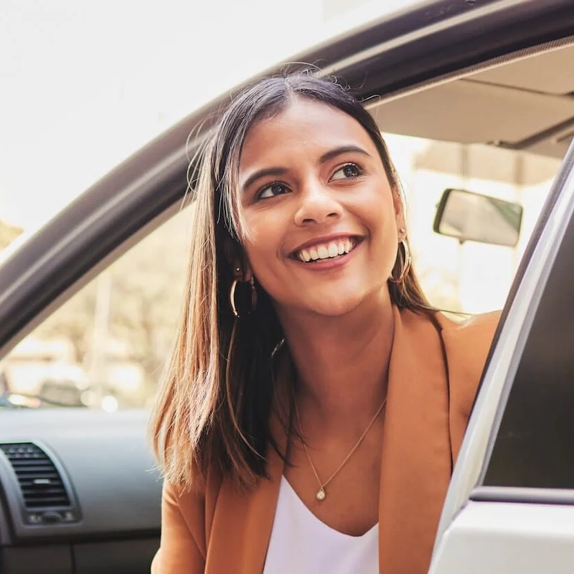 smiling woman getting out of car