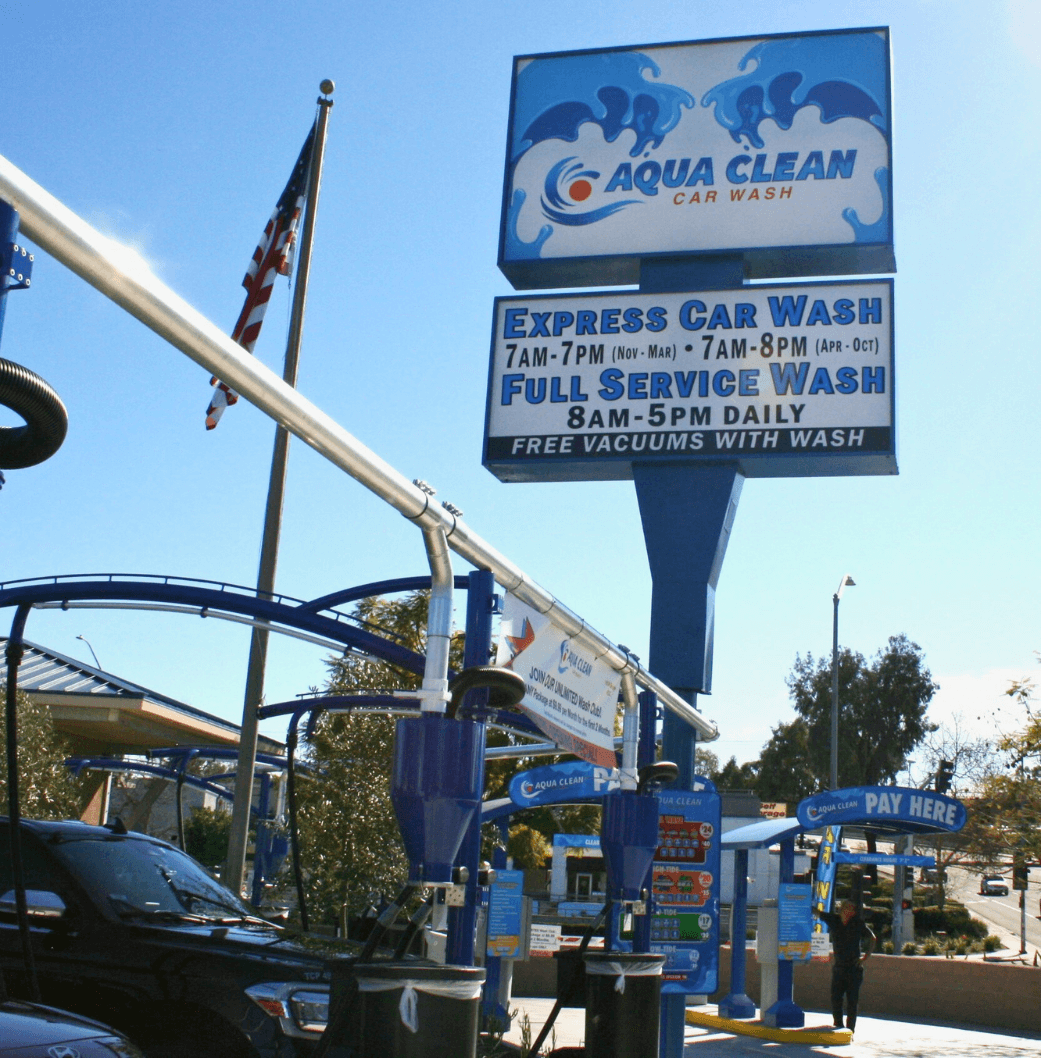 Vacuum area at Aqua Clean Car Wash with the large sign in the background that says "Aqua Clean Express Wash and Full Service Wash"