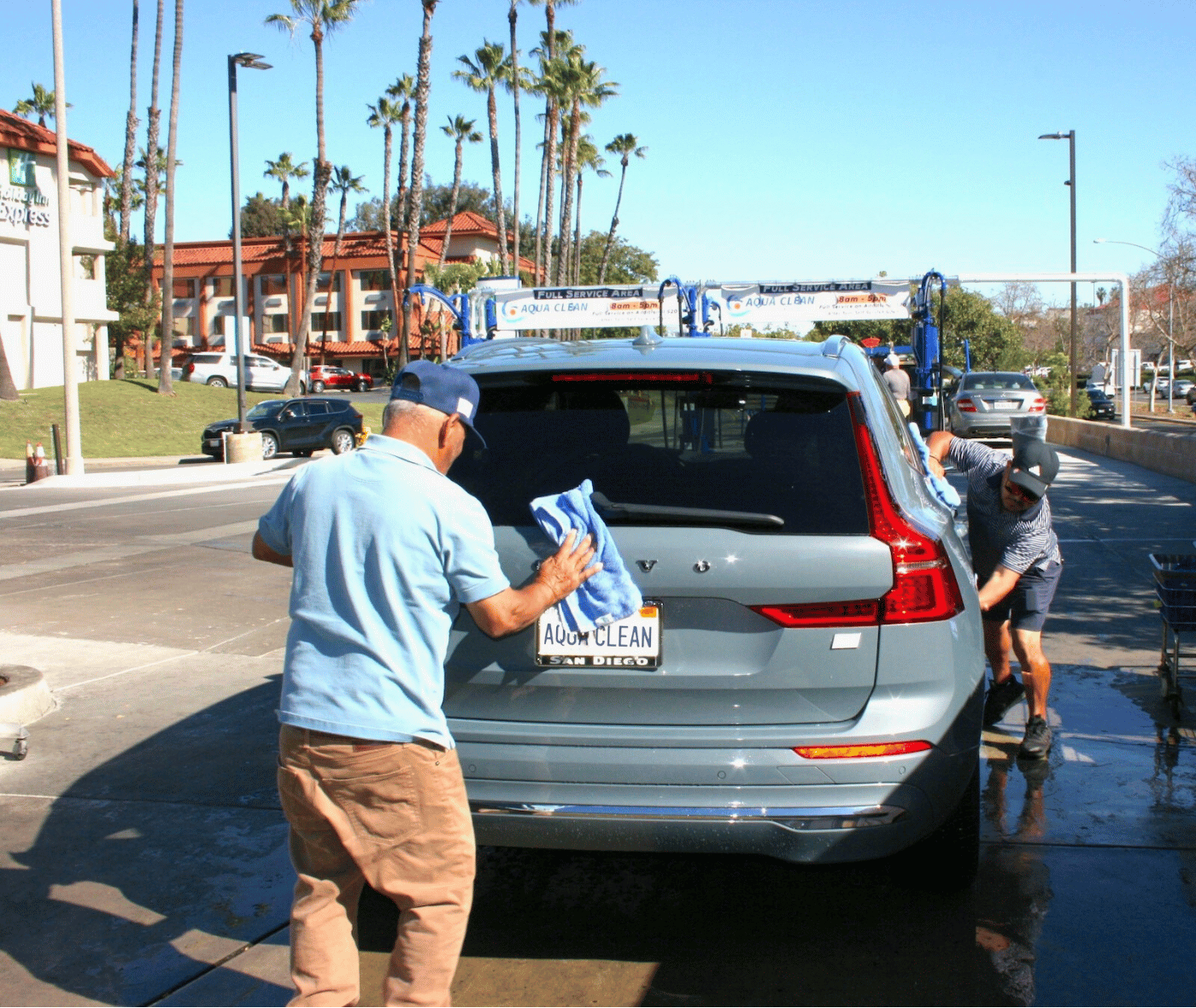 two employees hand-drying an SUV at Aqua Clean Car Wash in La Mesa, California