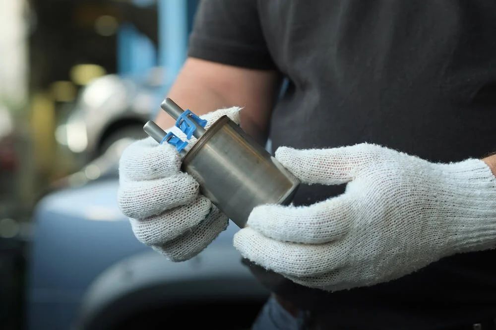 auto mechanic checks and monitors the serviceability of the fuel filter before installing it on the engine