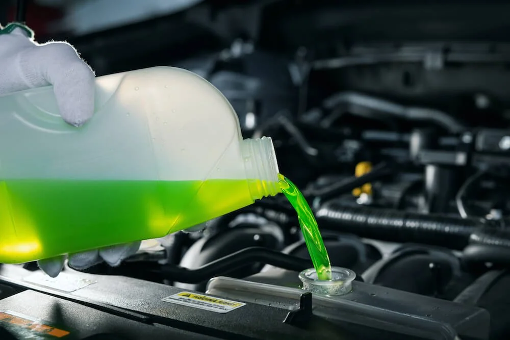 pouring green coolant into a car