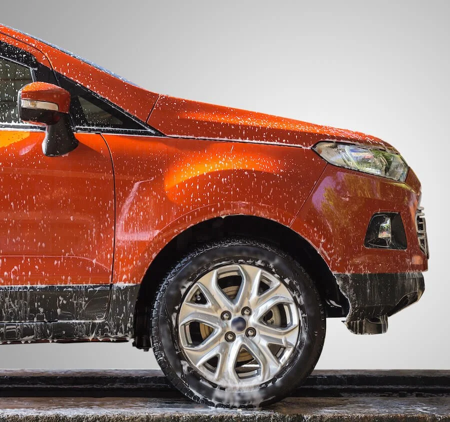 soapy orange SUV going through a car wash