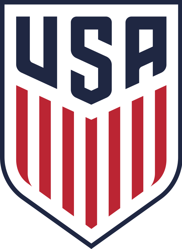 The US Soccer Team crest with a shield design, featuring "USA" at the top and red and white vertical stripes below.