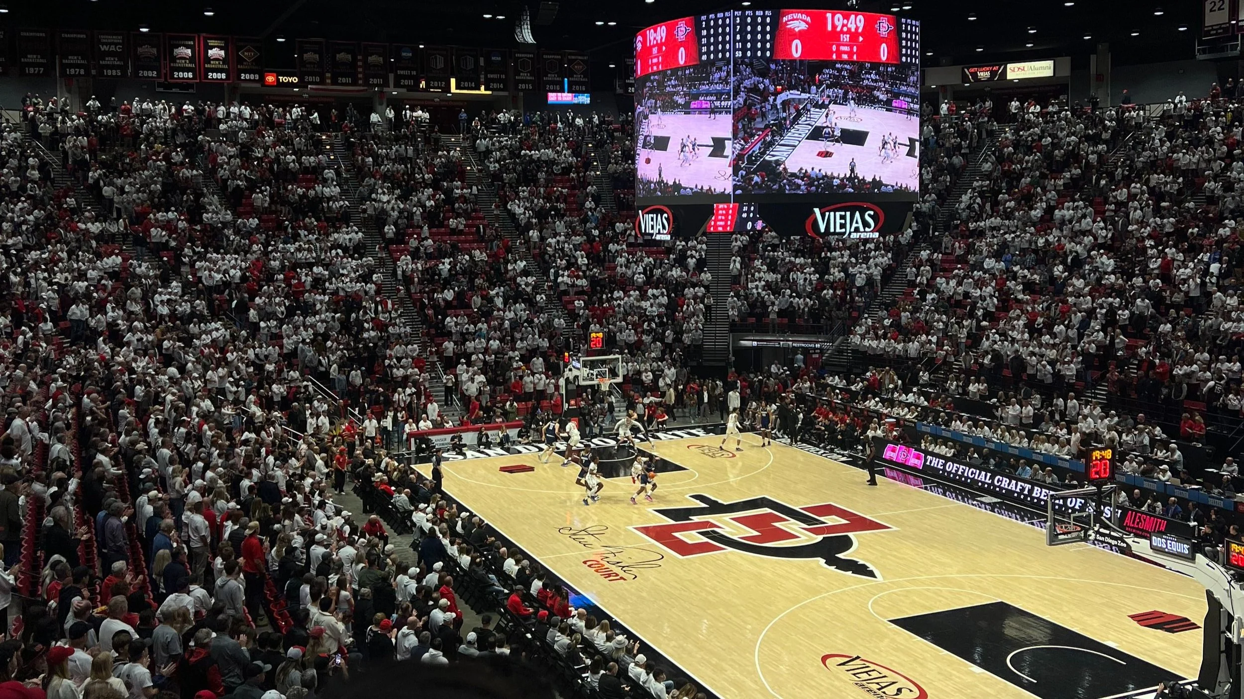 Indoor basketball game at Viejas Arena with a large crowd watching.