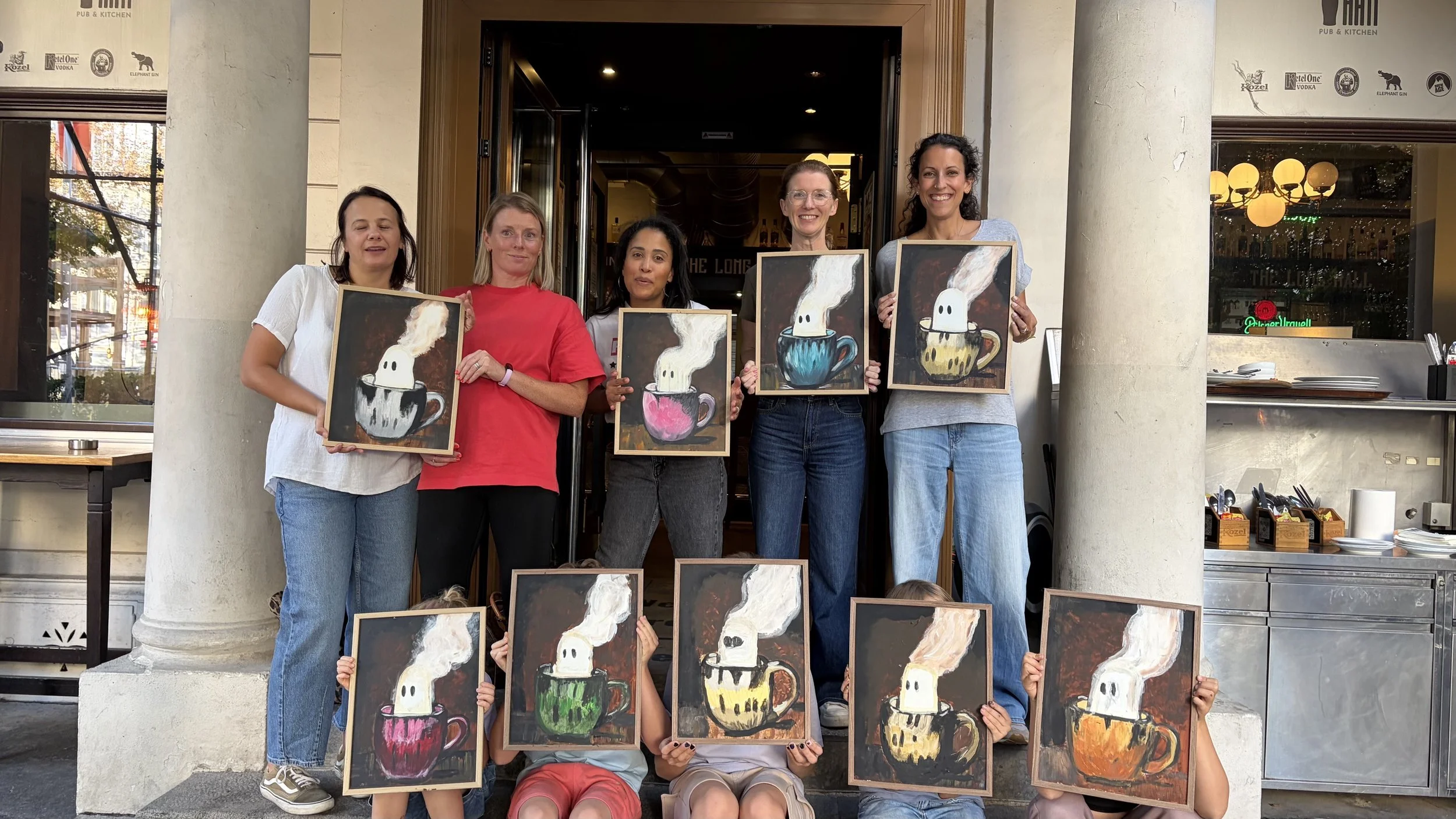 parents and children holding up their paintings