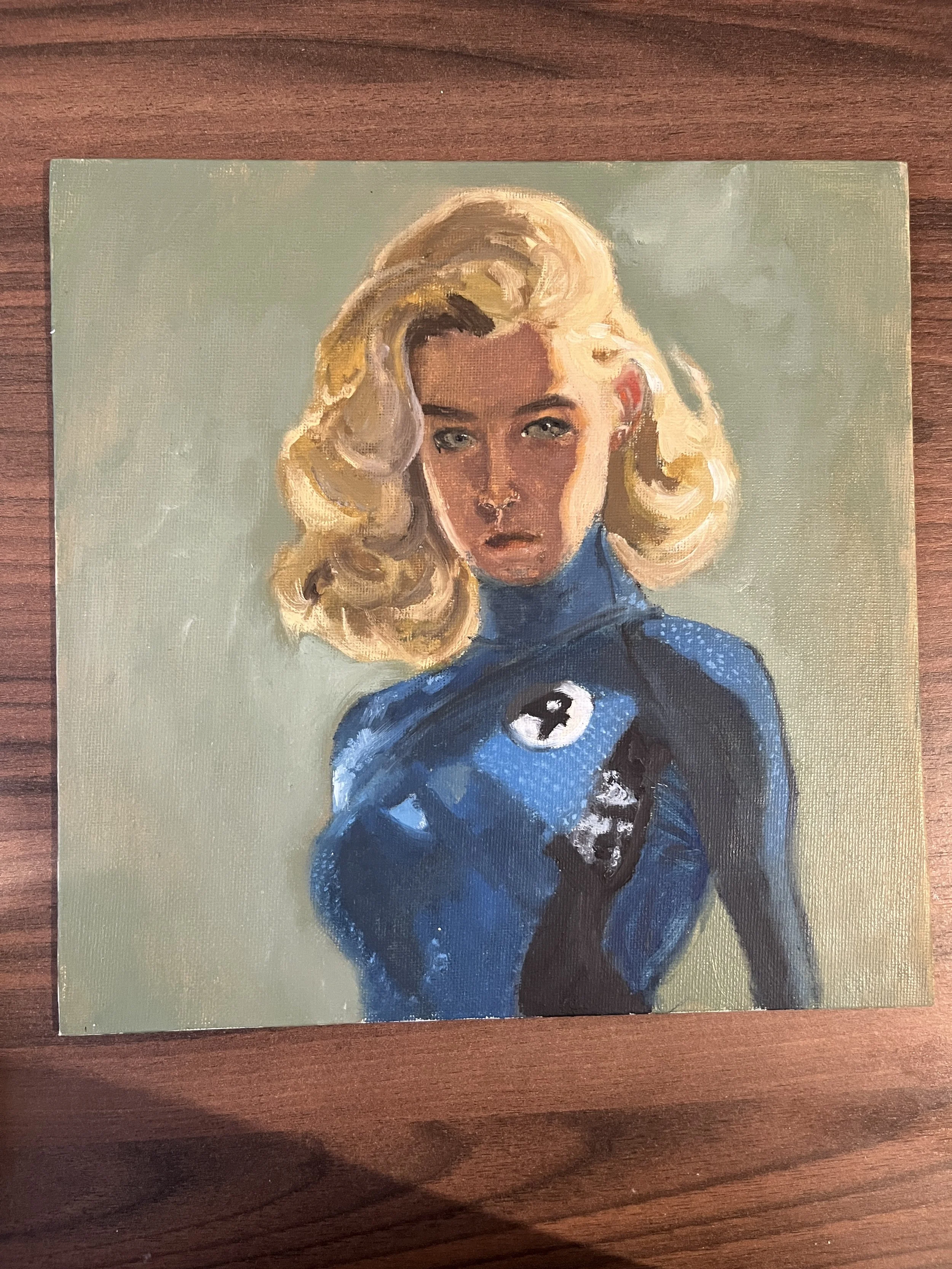 A painting of a woman with blonde, wavy hair wearing a blue superhero costume with a black cat emblem and a body suit with a high collar.