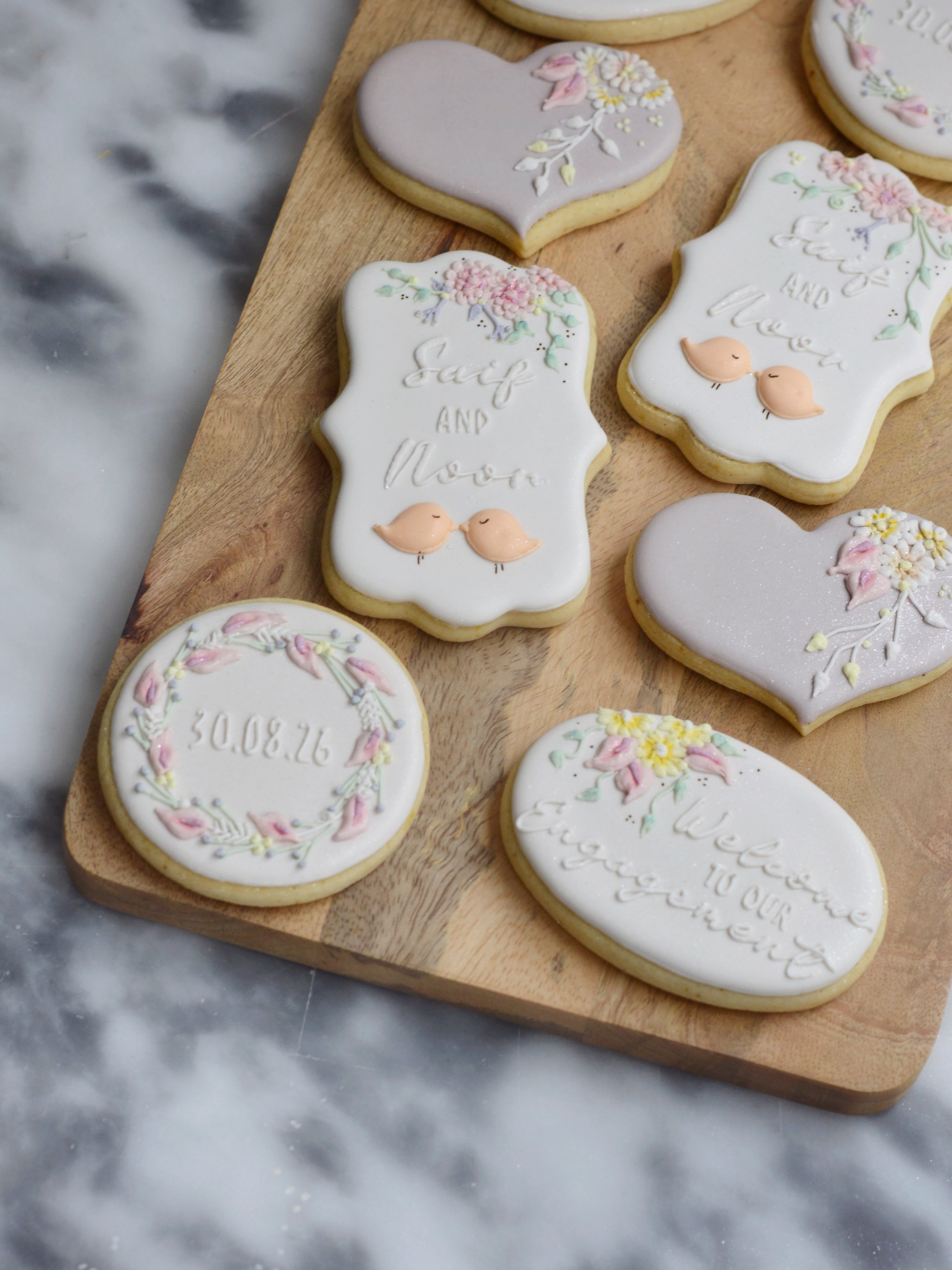These bespoke engagement cookies were made for Saif and Noor&rsquo;s celebration, hand piped in soft lilac and blush with delicate florals and the sweetest little love birds 🐦 
Made for the lovely team at @cheeseandtreats, who brought me on board to