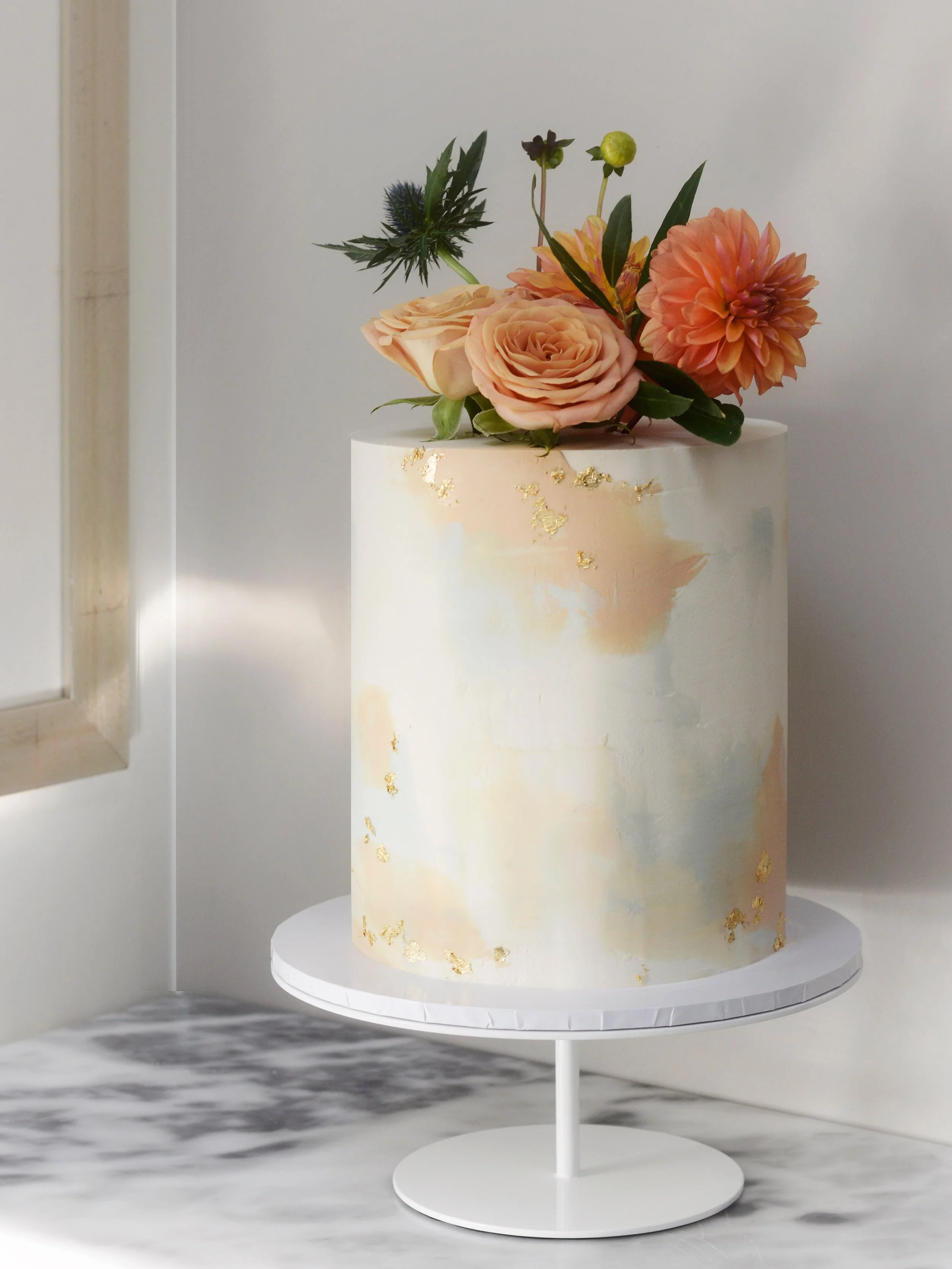 Who says you need five tiers to steal the show?
One tier, big impact. Soft watercolour white chocolate ganache, a scatter of gold leaf and beautiful autumn blooms for Jason &amp; Michael&rsquo;s wedding last Saturday.
Congratulations to you both, her