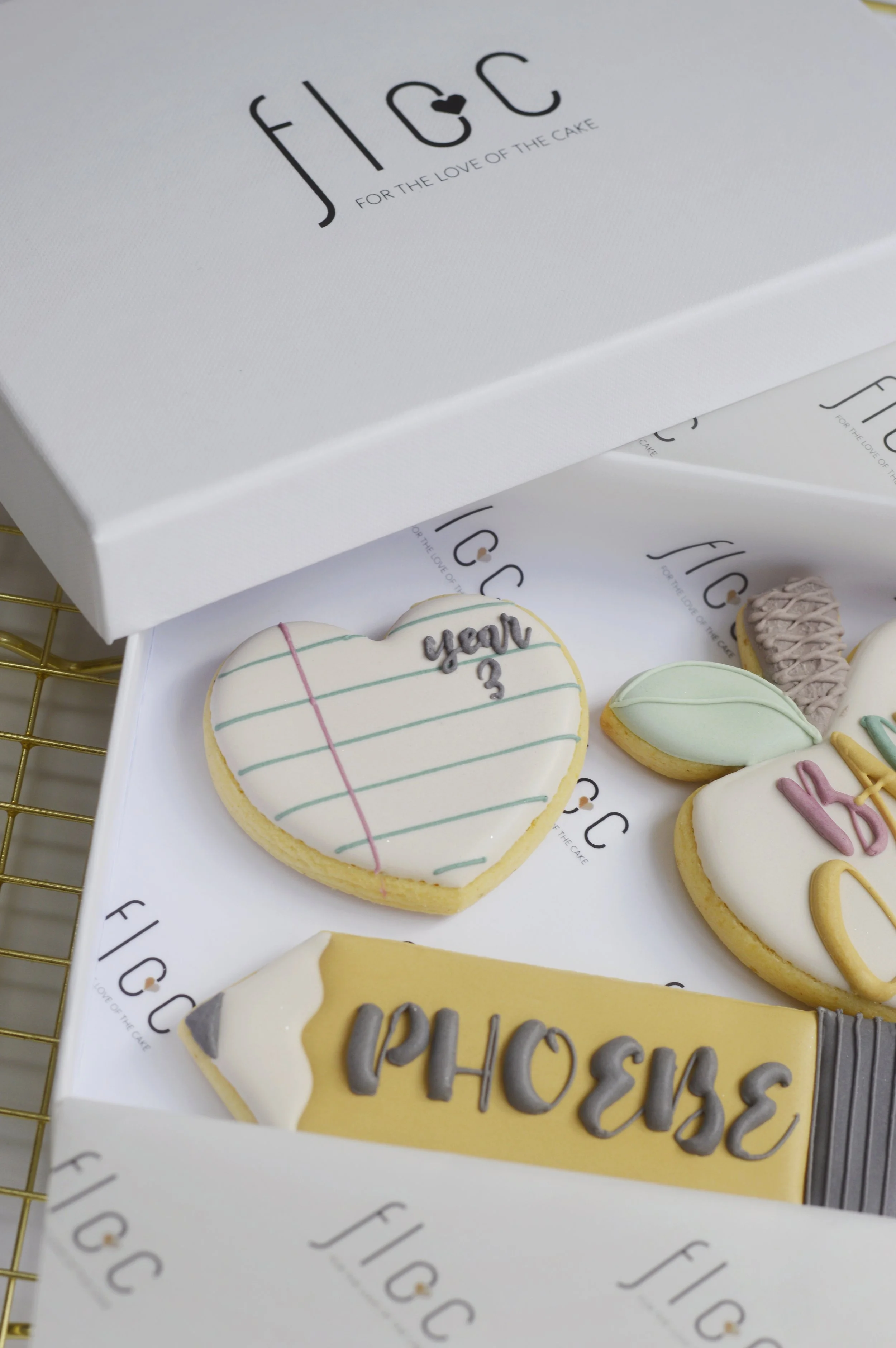 Close-up of a personalised Year 3 heart-shaped cookie with hand-piped notebook lines, part of a Back to School cookie box by Floc Bakes