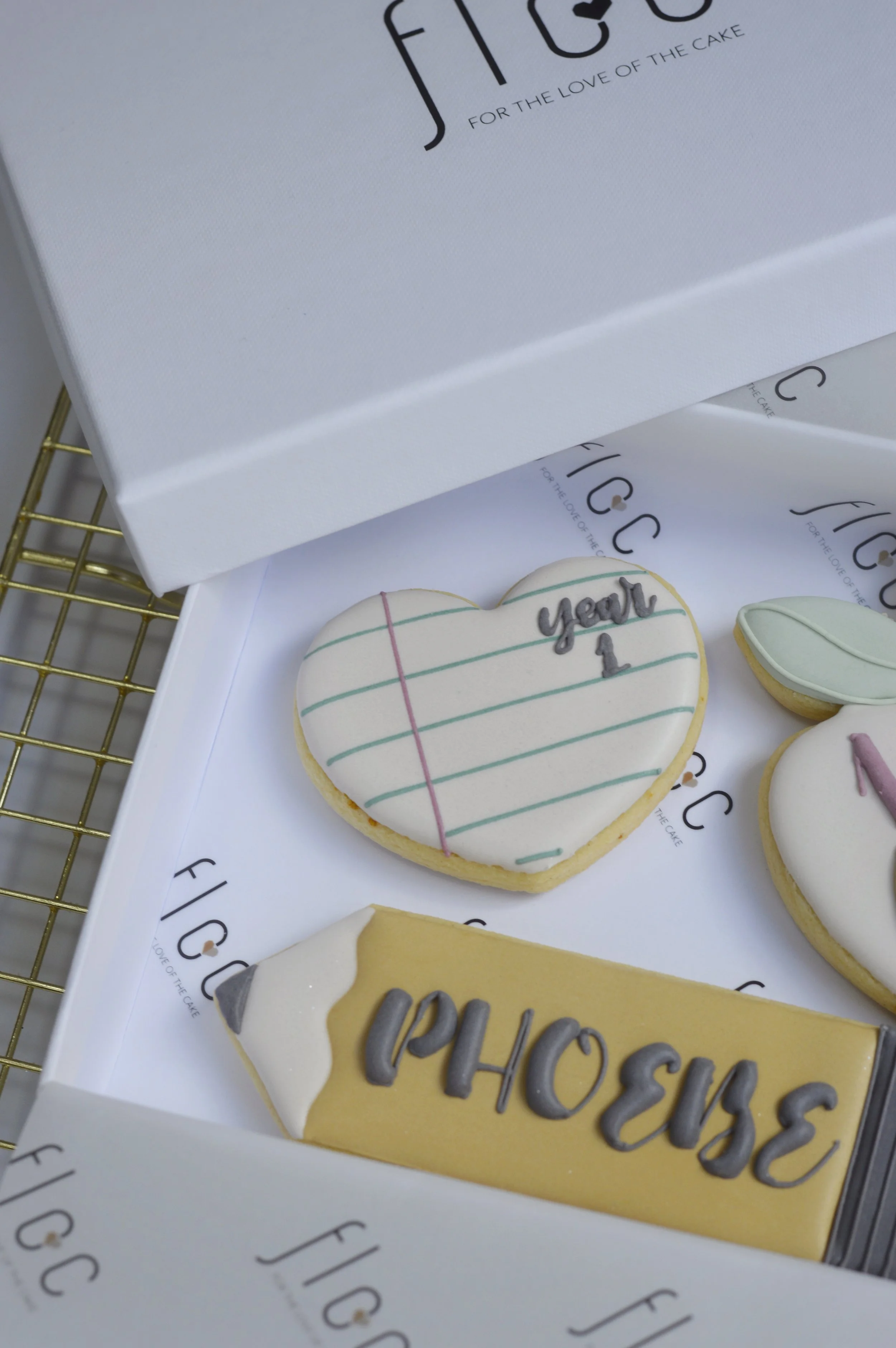 Close-up of a personalised Year 1 heart-shaped cookie with hand-piped notebook lines, part of a First Day of School cookie box by Floc Bakes